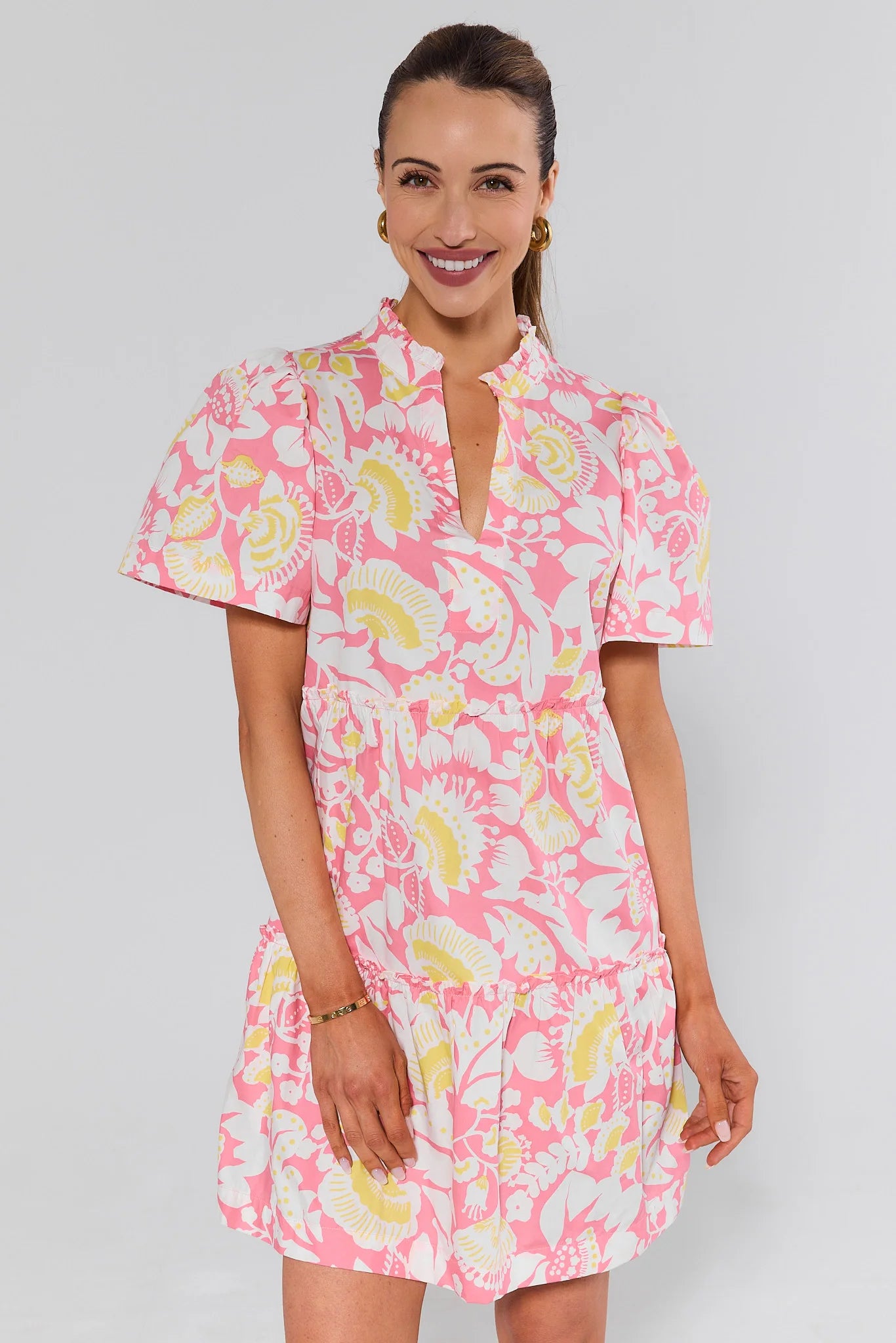 Woman wearing a pink floral dress against a gray background