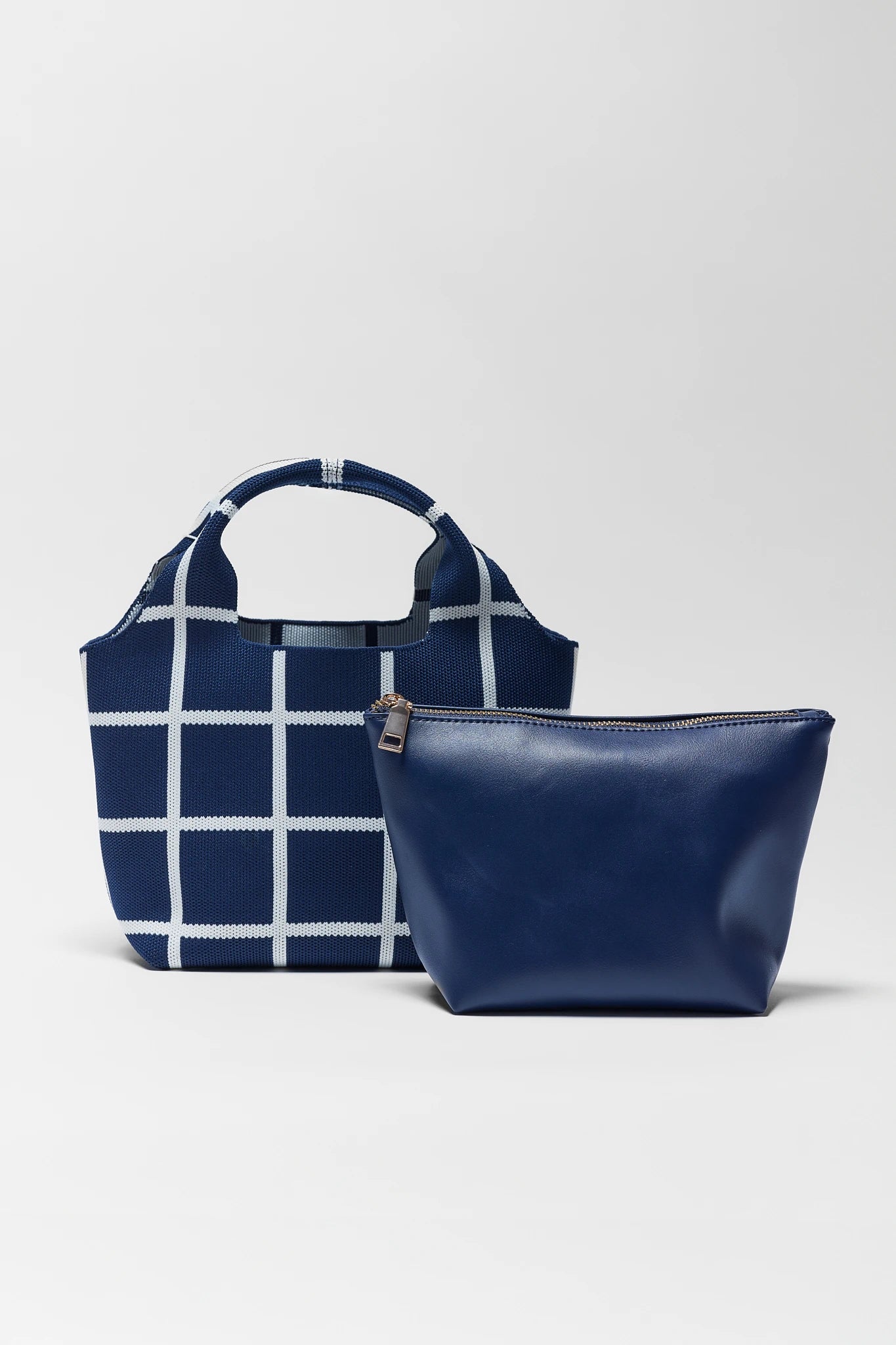 Navy blue and white checkered bag with a matching pouch on a light gray background
