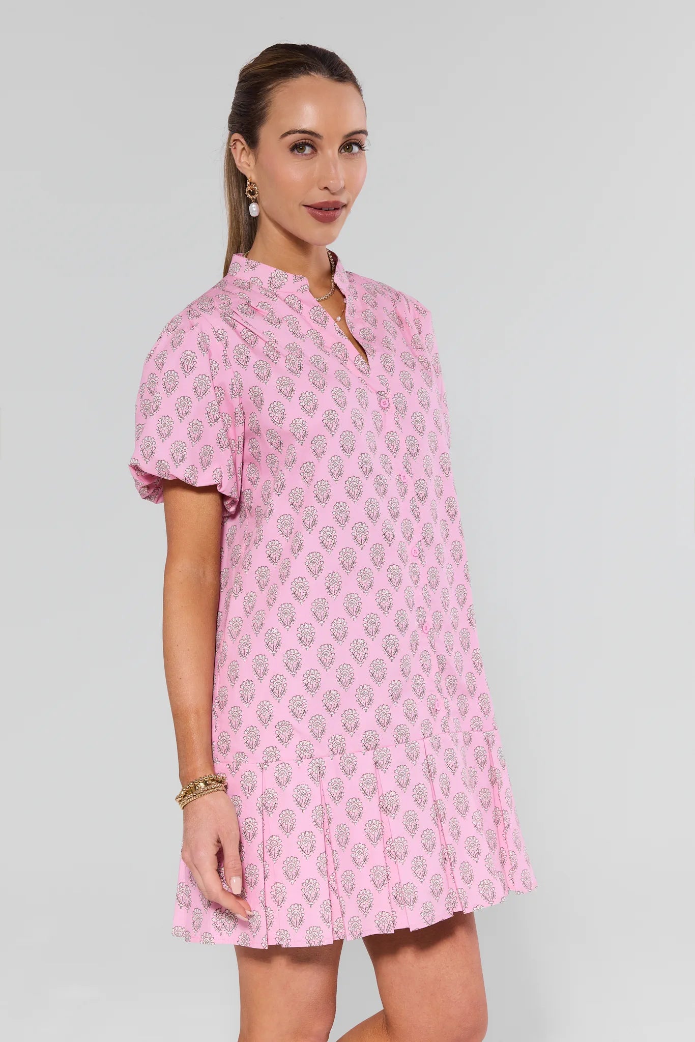 Woman wearing a pink patterned dress on a background