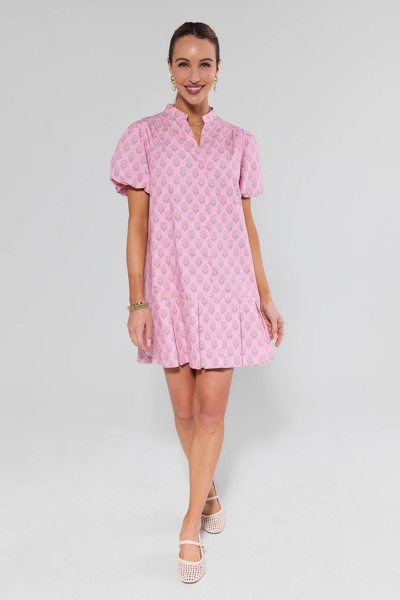 Woman wearing a pink patterned dress on a white background