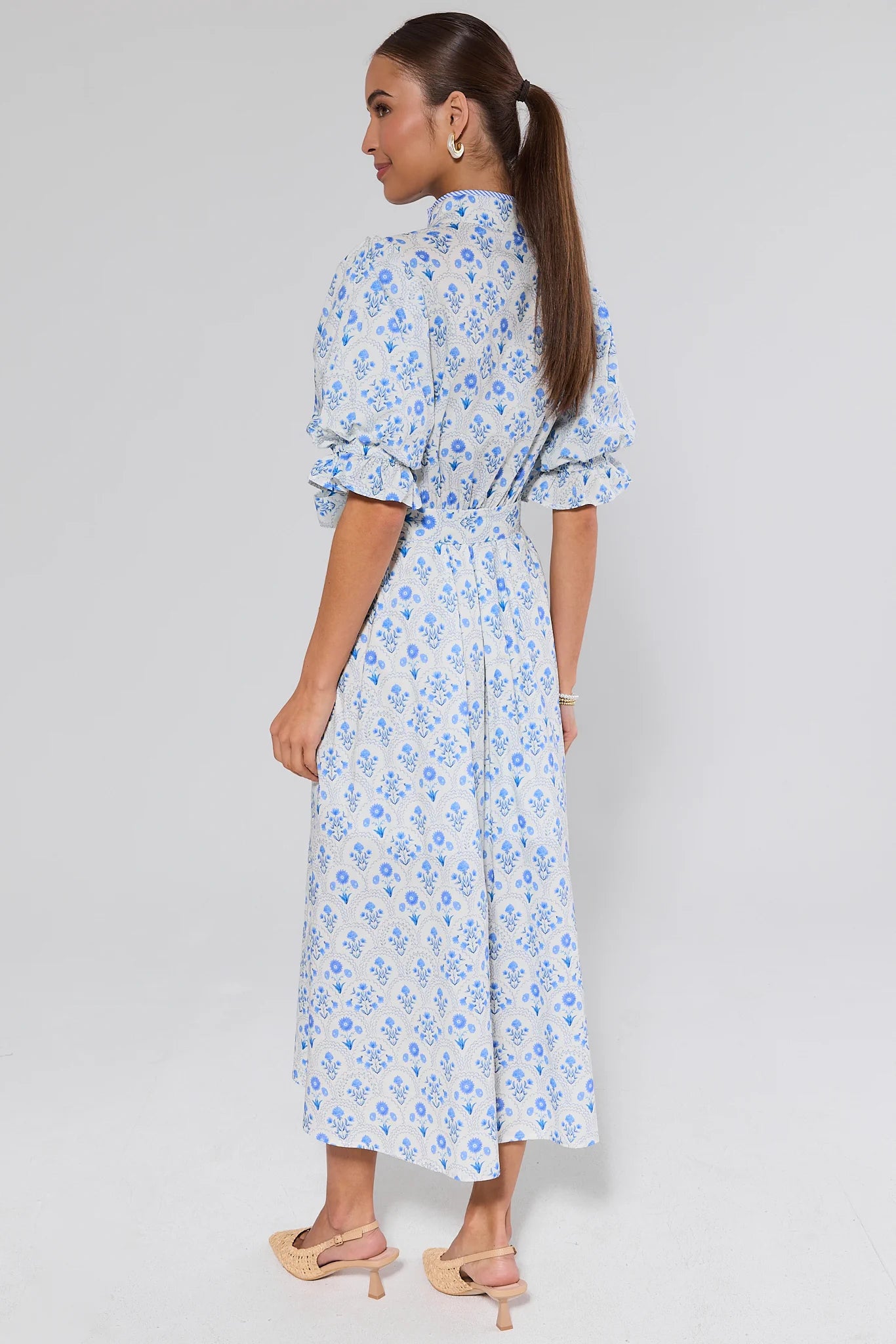 Woman wearing a blue floral dress on a white background