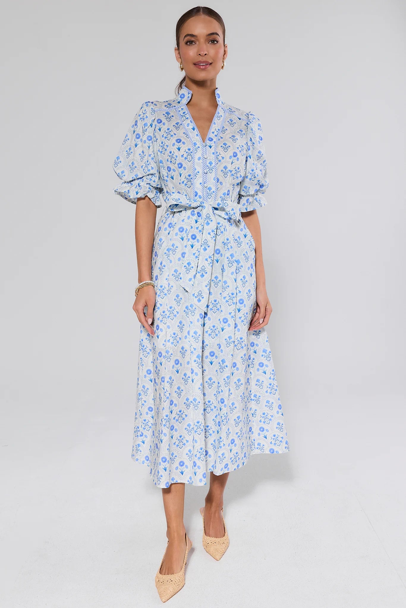 Woman wearing a blue floral dress on a white background
