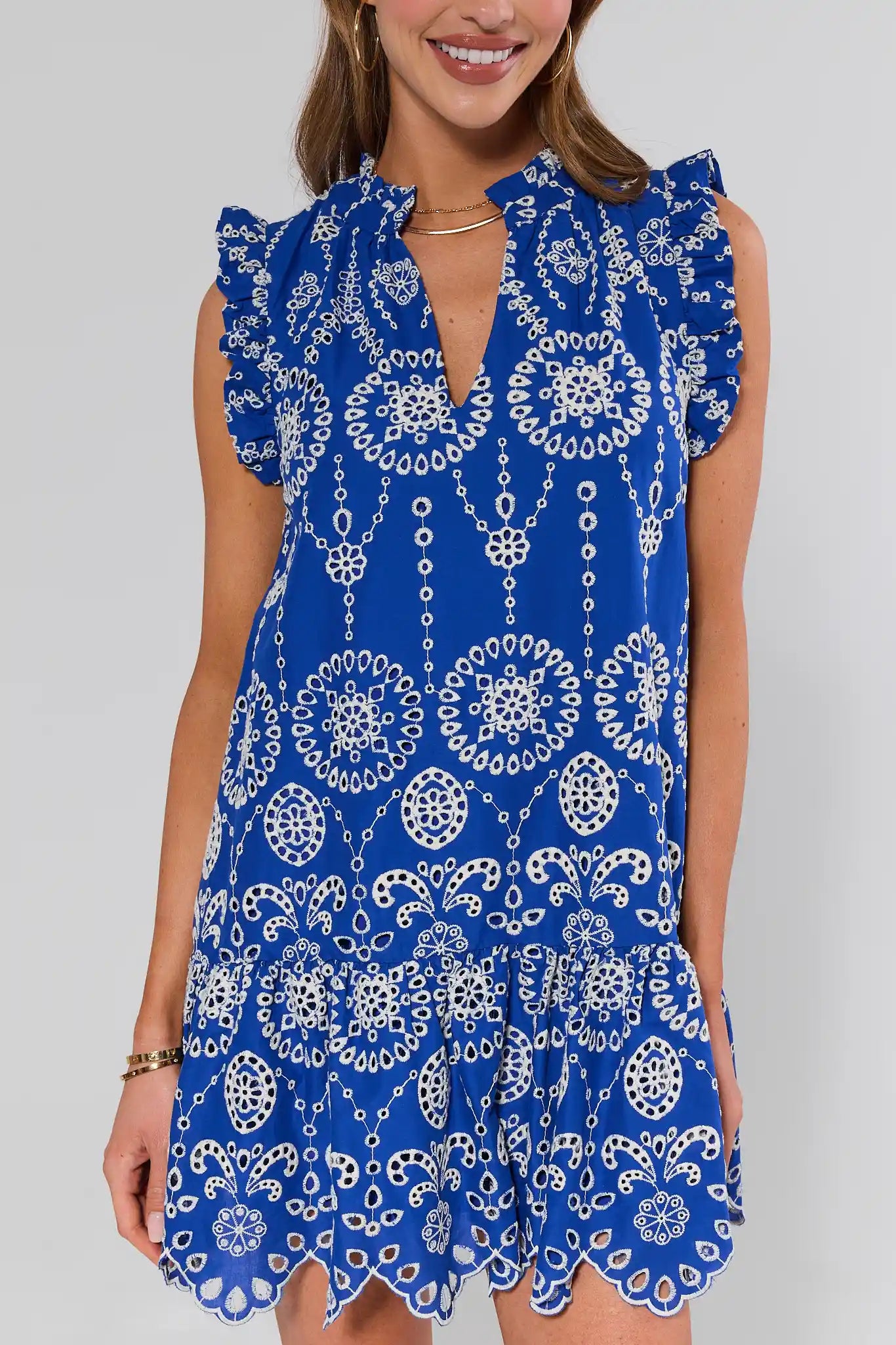 close up Woman wearing a blue and white patterned dress against a plain background