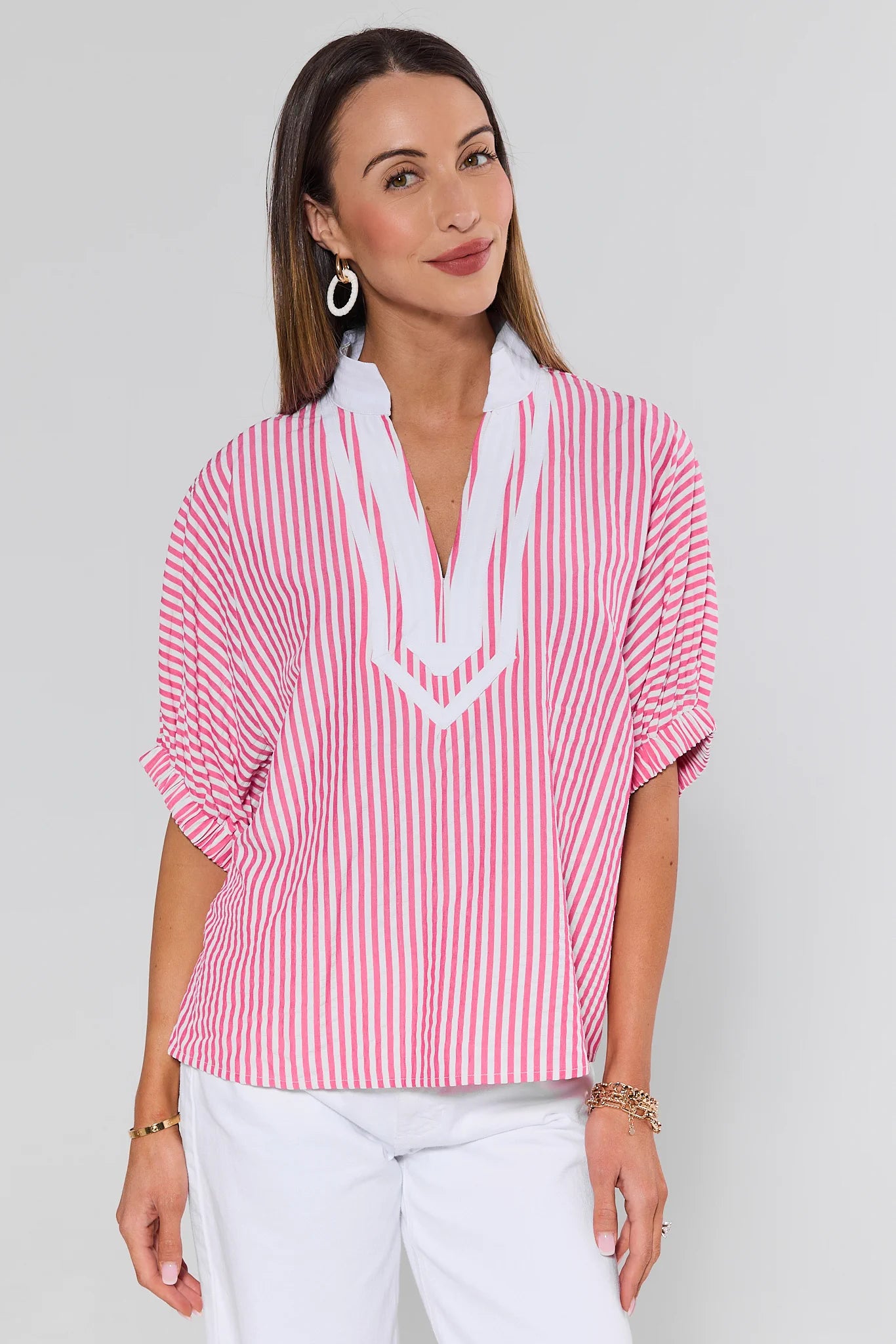 Woman wearing a red and white striped blouse with a plain background