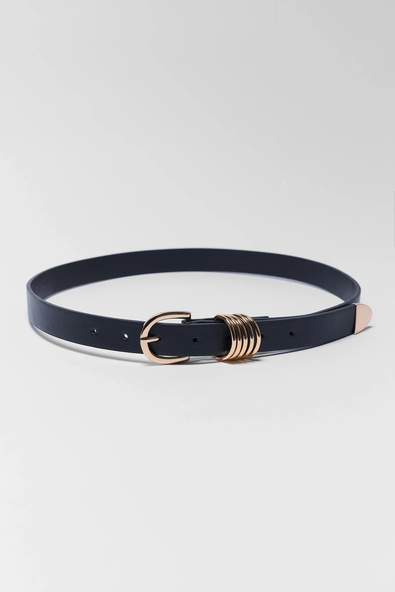 Black belt with a gold buckle on a light gray background
