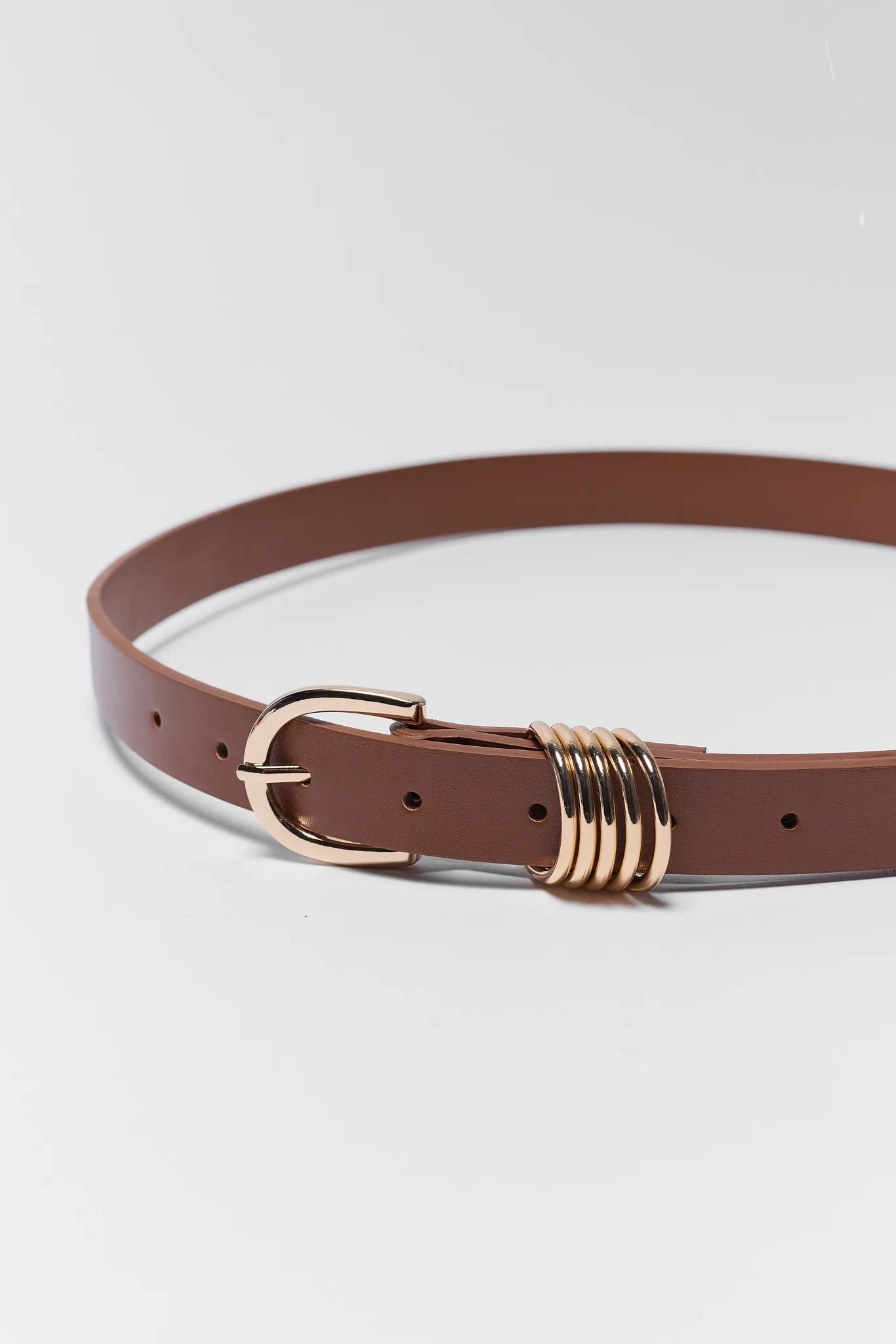 Brown belt with a gold buckle on a light gray background