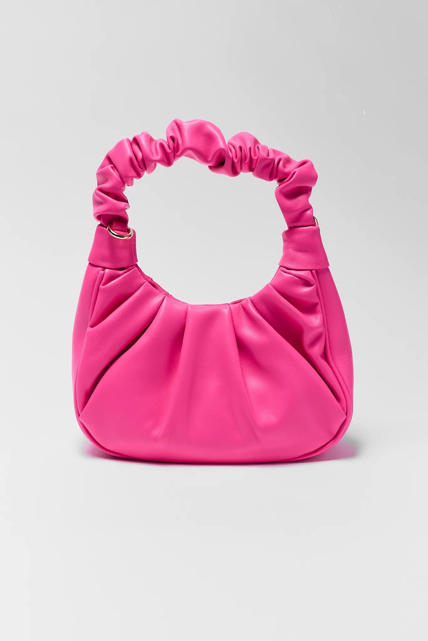 Pink handbag with ruched handles on a light gray background
