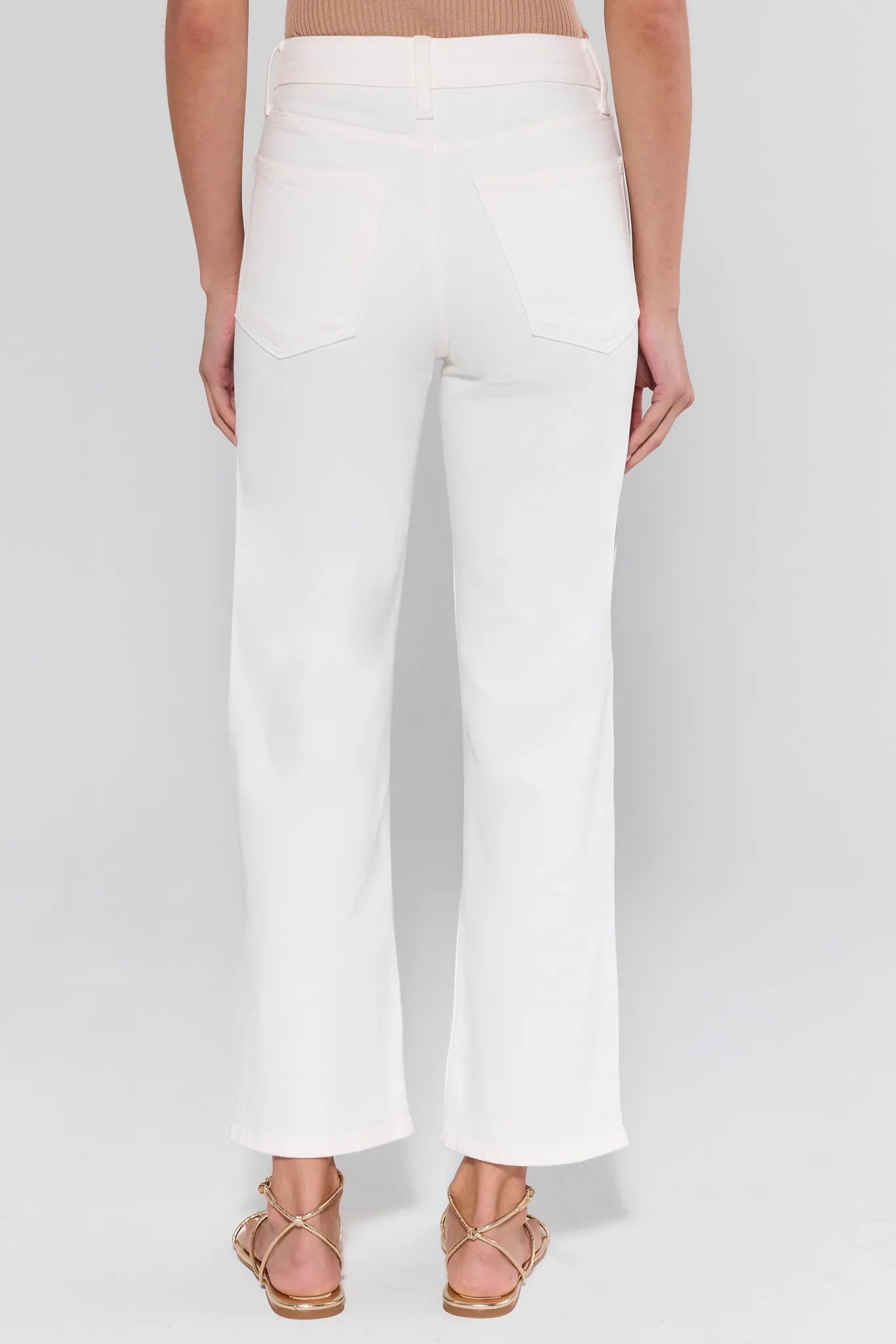 White pants worn by a person on a white background