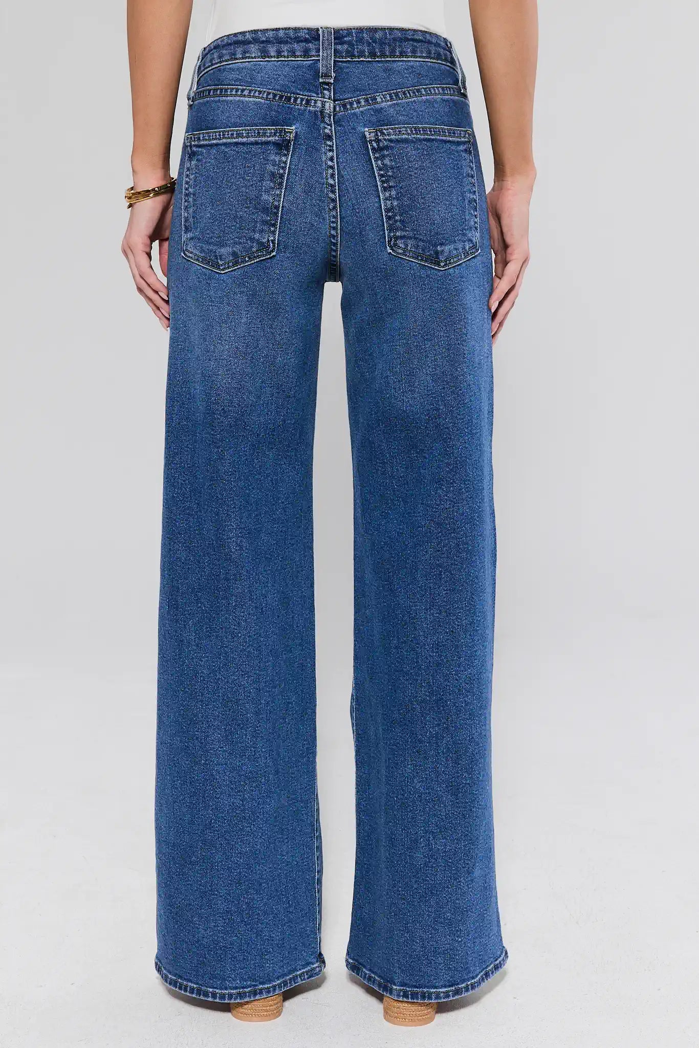 Blue jeans worn by a person on a white background