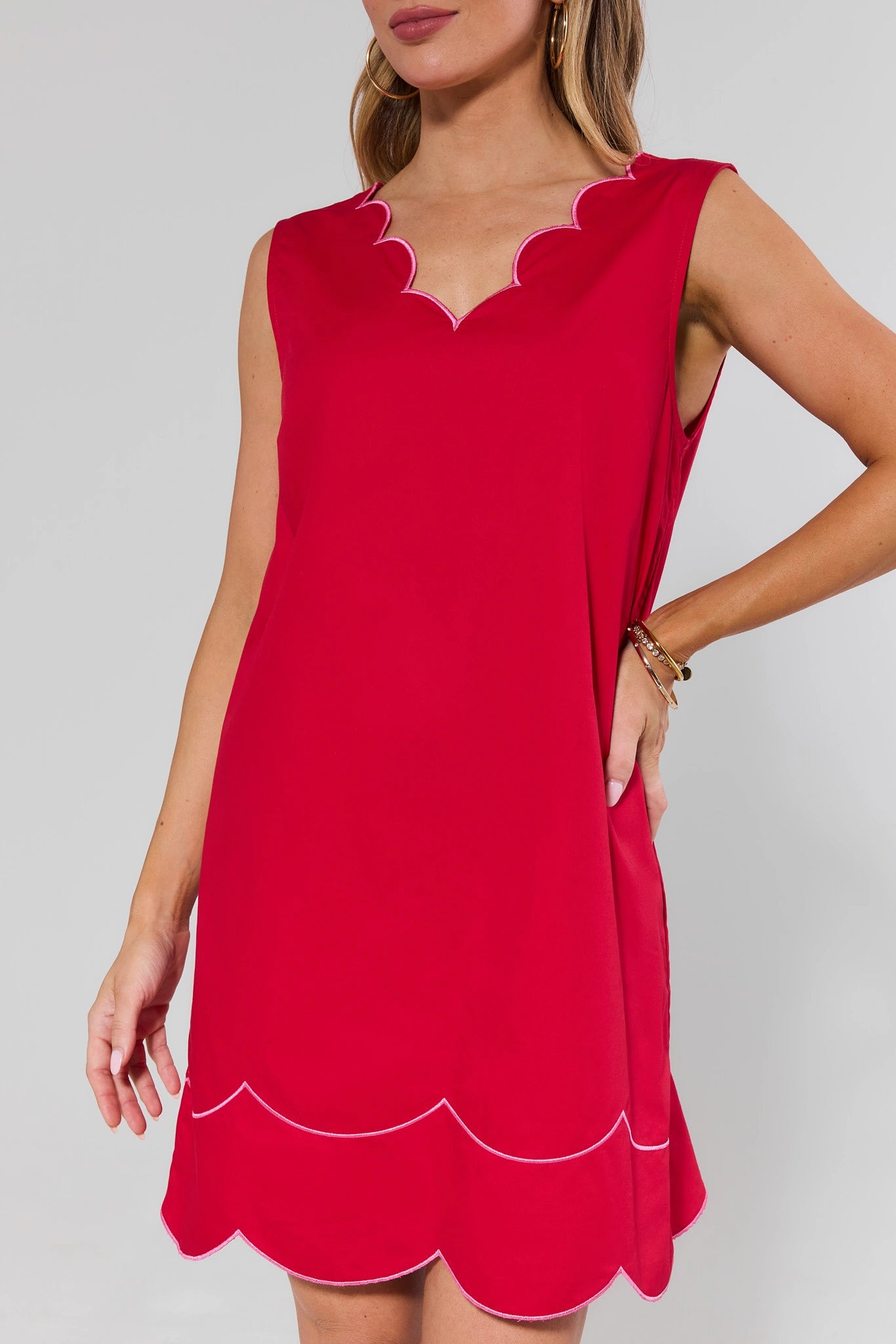 close up Red dress with scalloped edges on a plain background