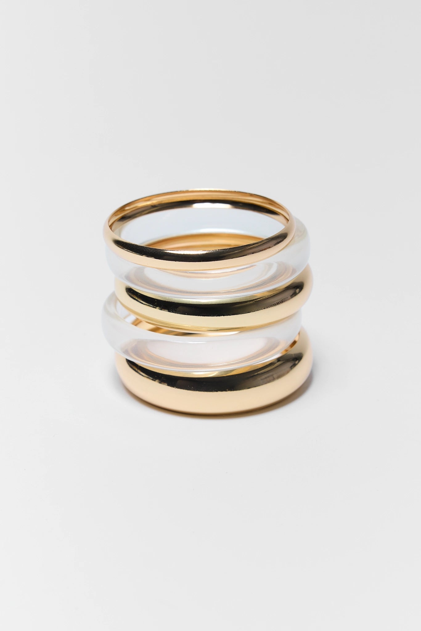Stack of three gold and silver rings on a white background