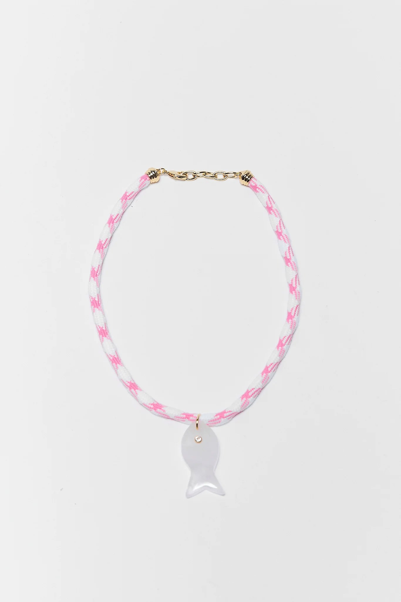Necklace with pink and white fish pendant on a light gray background