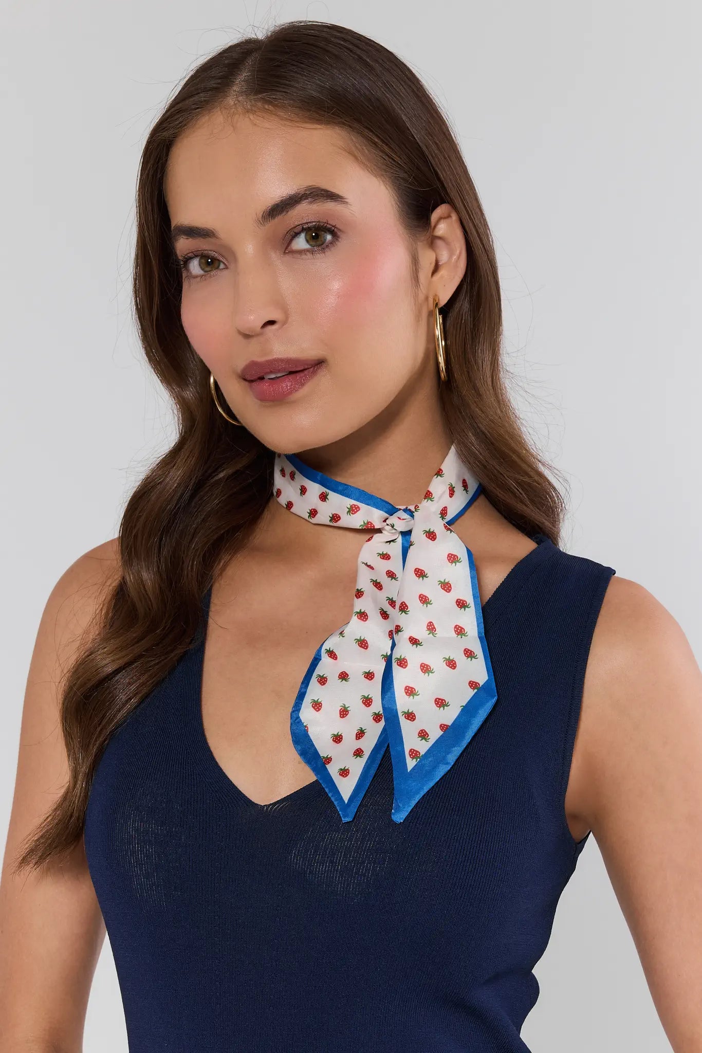 woman wearing strawberry print neck scarf on white background