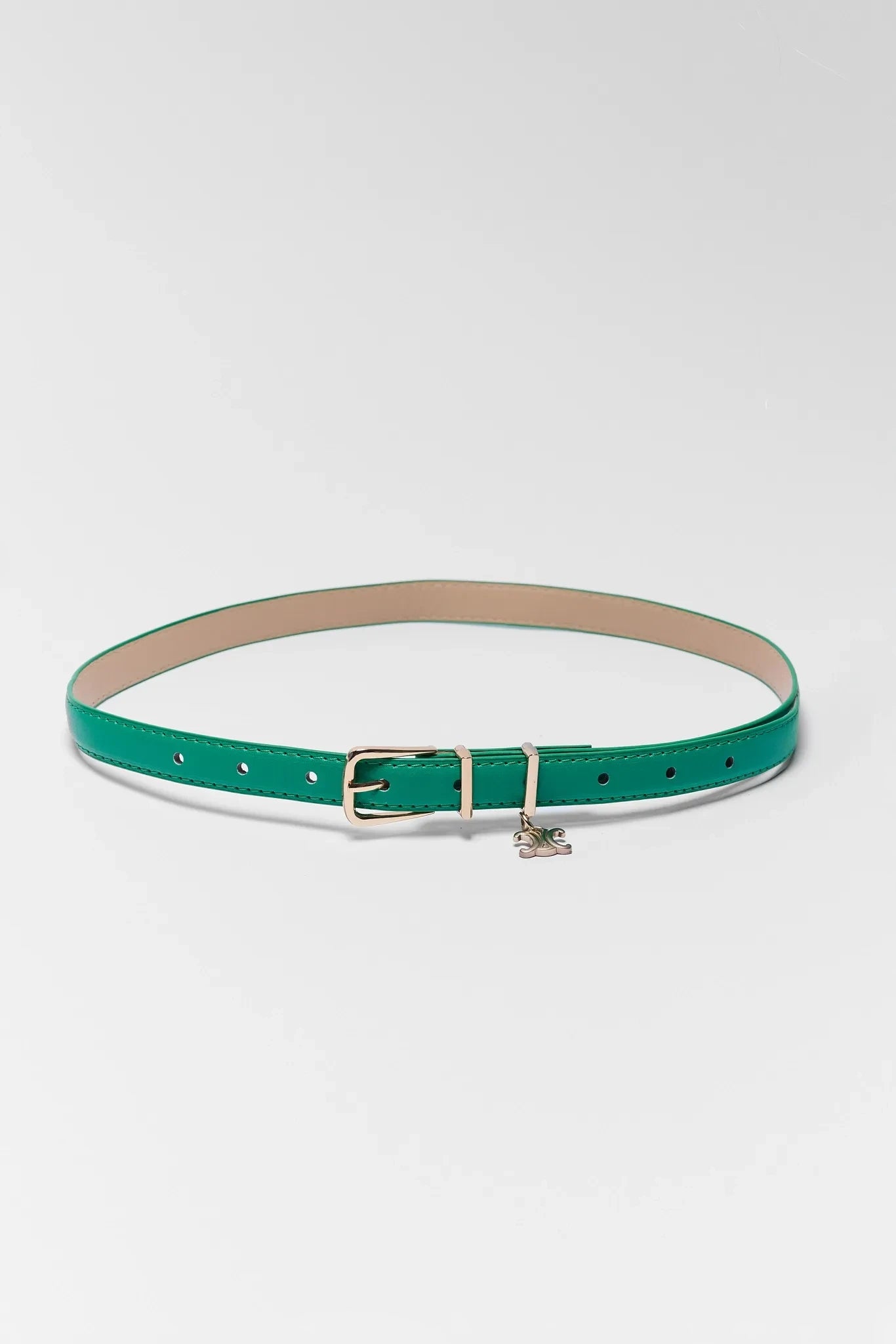 Green belt with a gold buckle on a light gray background
