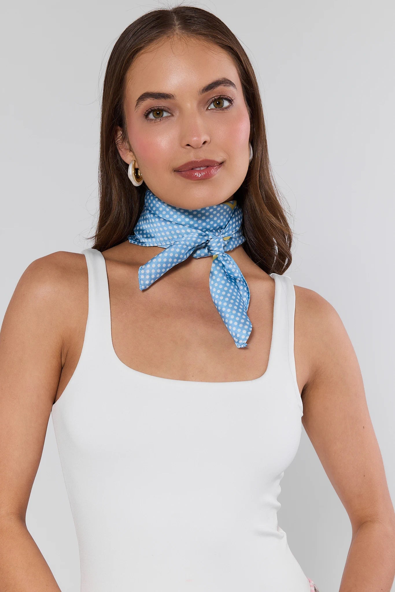 woman wearing annie blue scarf on her neck and white tank on white background