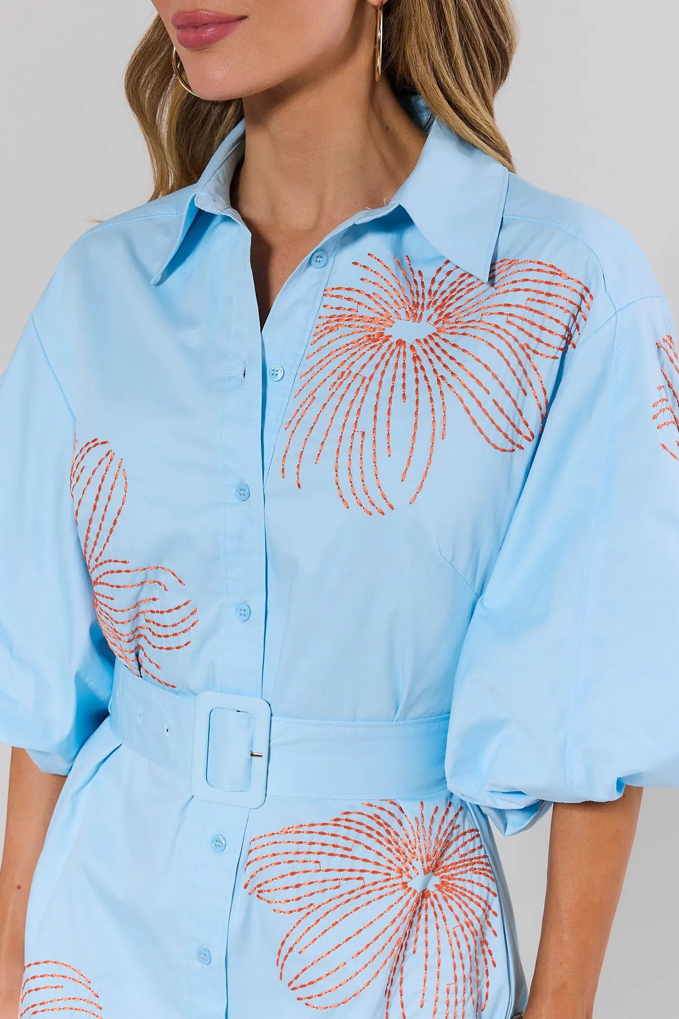 close up Light blue shirt with orange floral patterns worn by a person