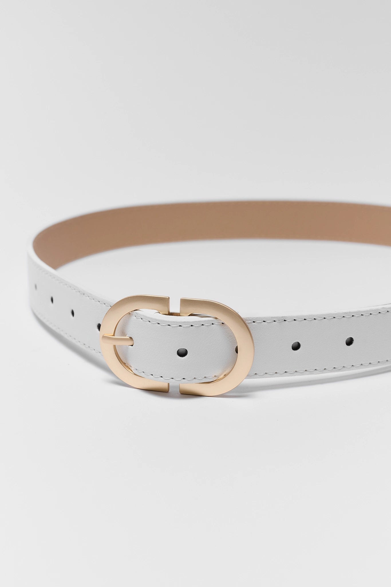 White belt with a gold buckle on a light gray background