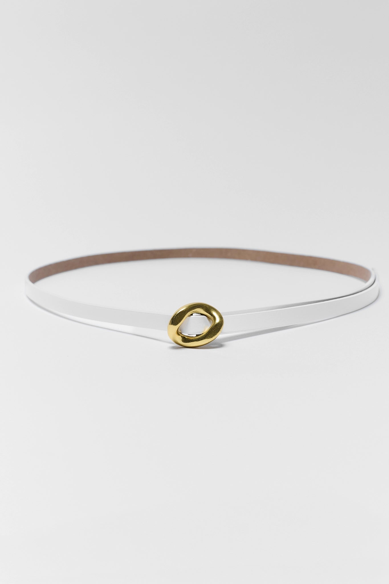 White belt with a gold buckle on a light gray background