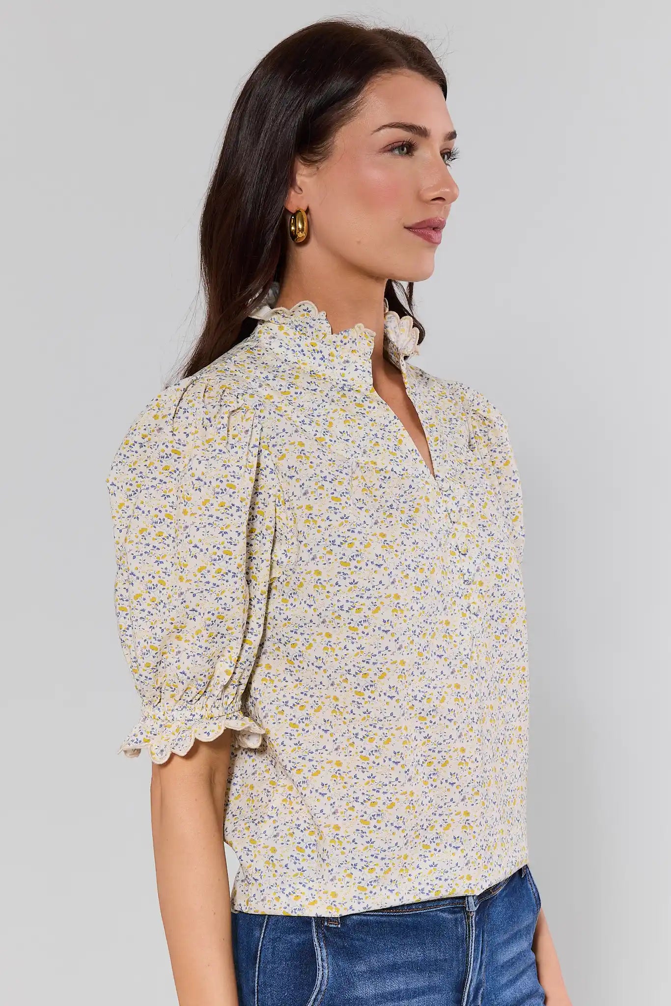 side shot Woman wearing a floral blouse against a plain background