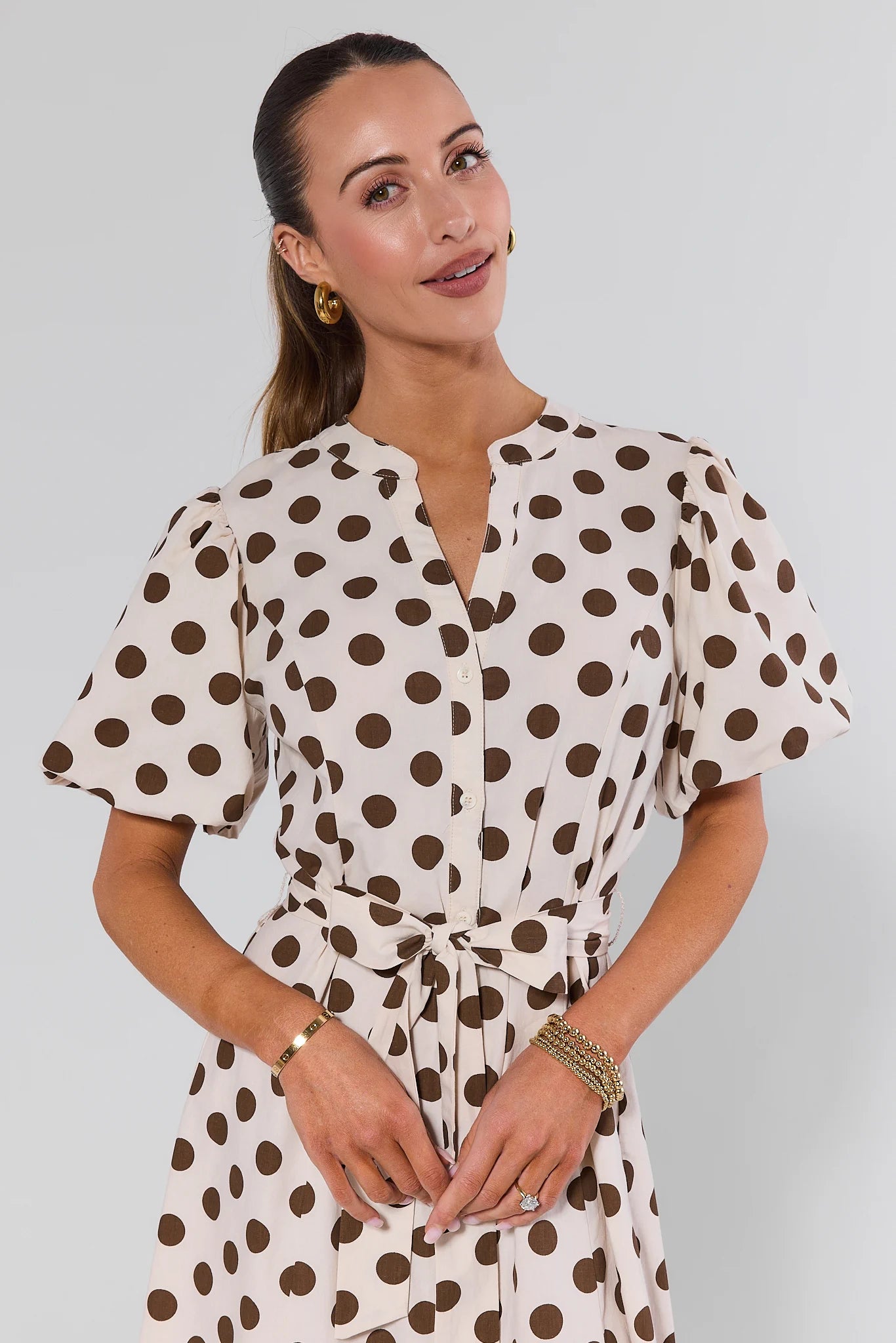 Woman wearing a polka dot dress against a plain background