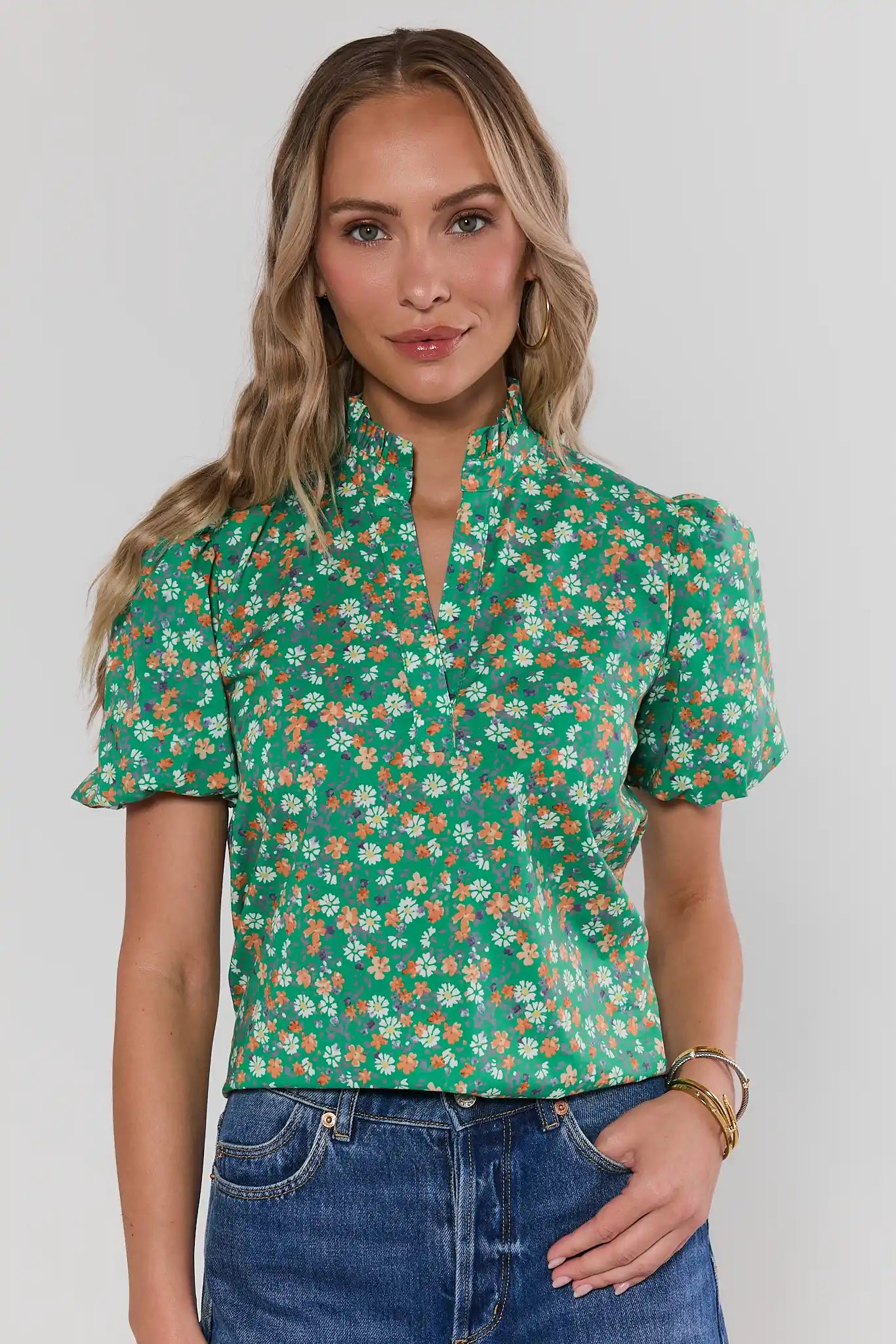 Woman wearing a green floral blouse against a white background