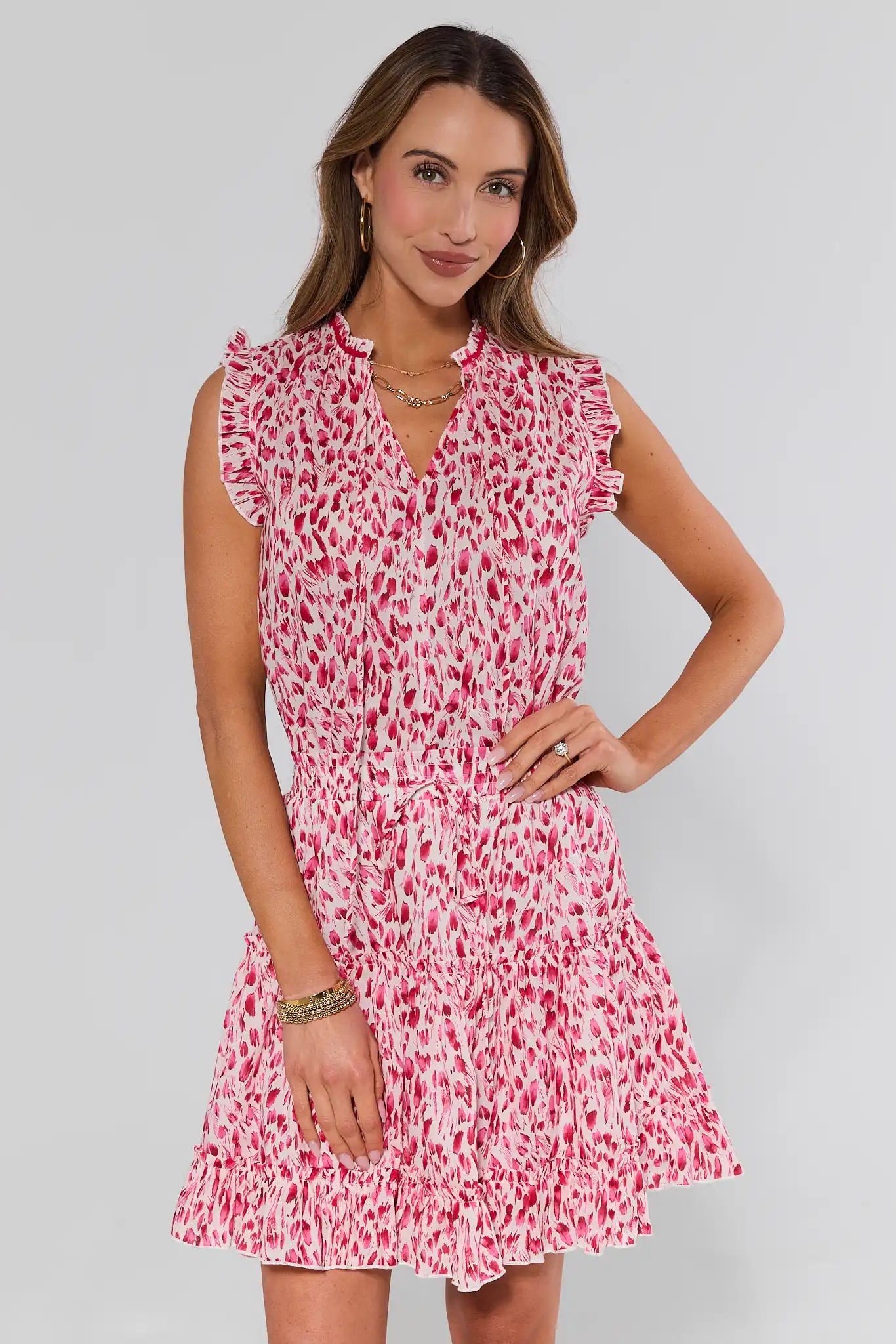 Woman wearing a pink and white patterned dress on a gray background