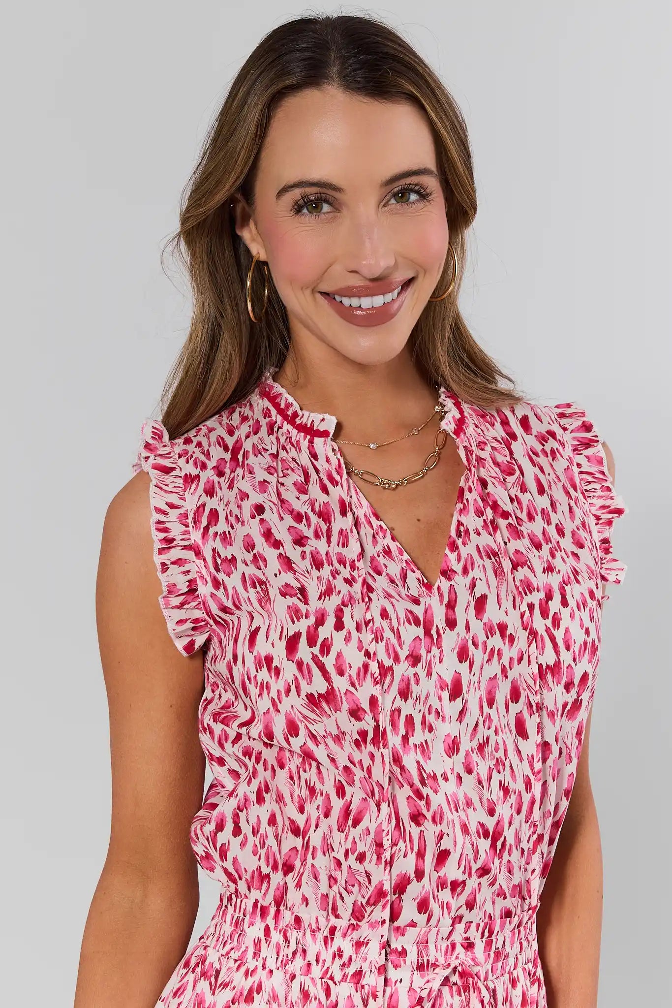 close up Woman wearing a pink and white patterned dress against a plain background