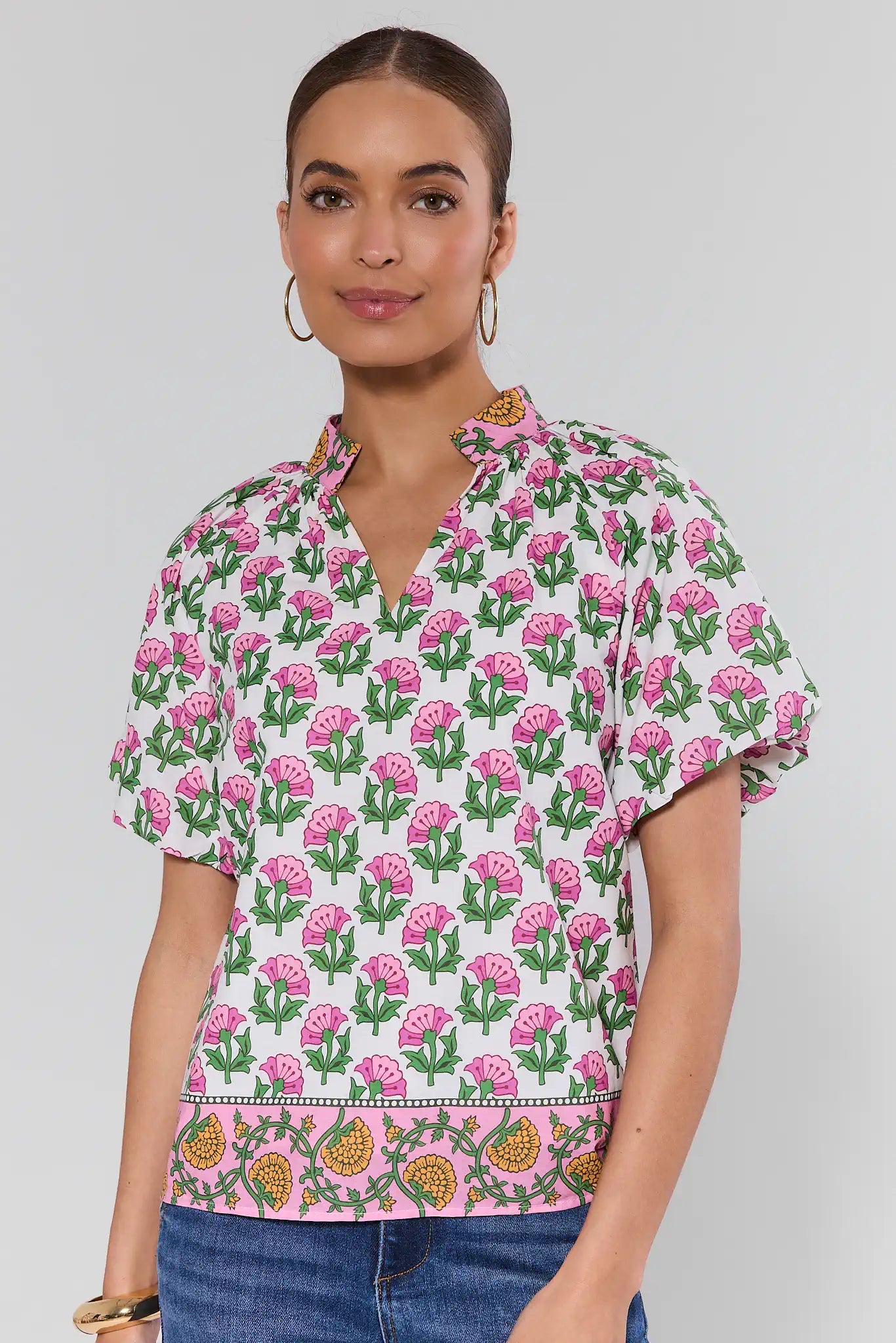 Woman wearing a floral patterned blouse with a plain background