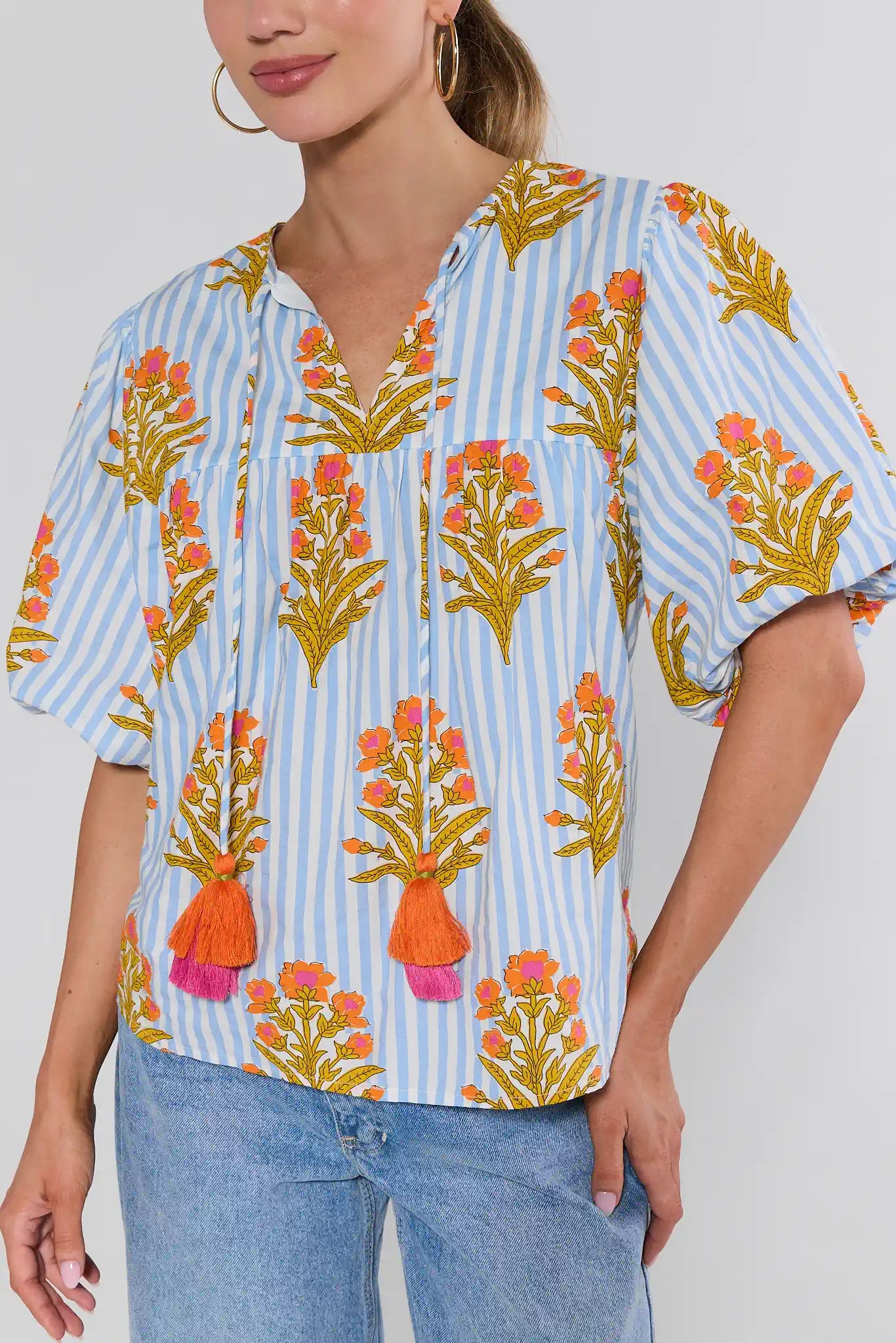 Woman wearing a colorful floral blouse with a white background