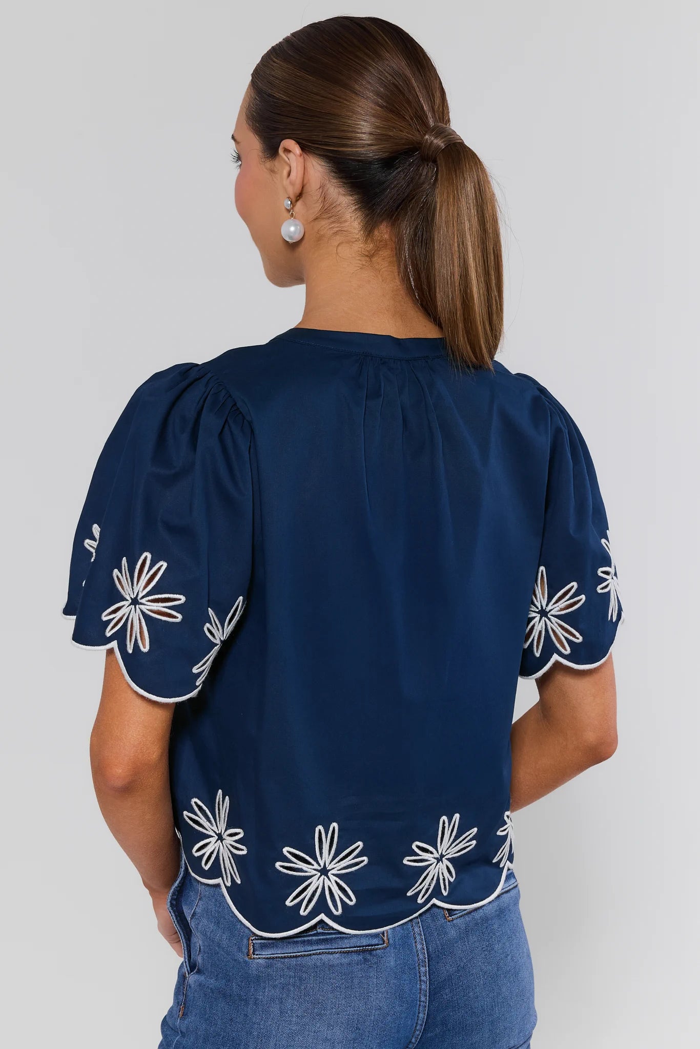 Navy blue blouse with white floral patterns on a plain background