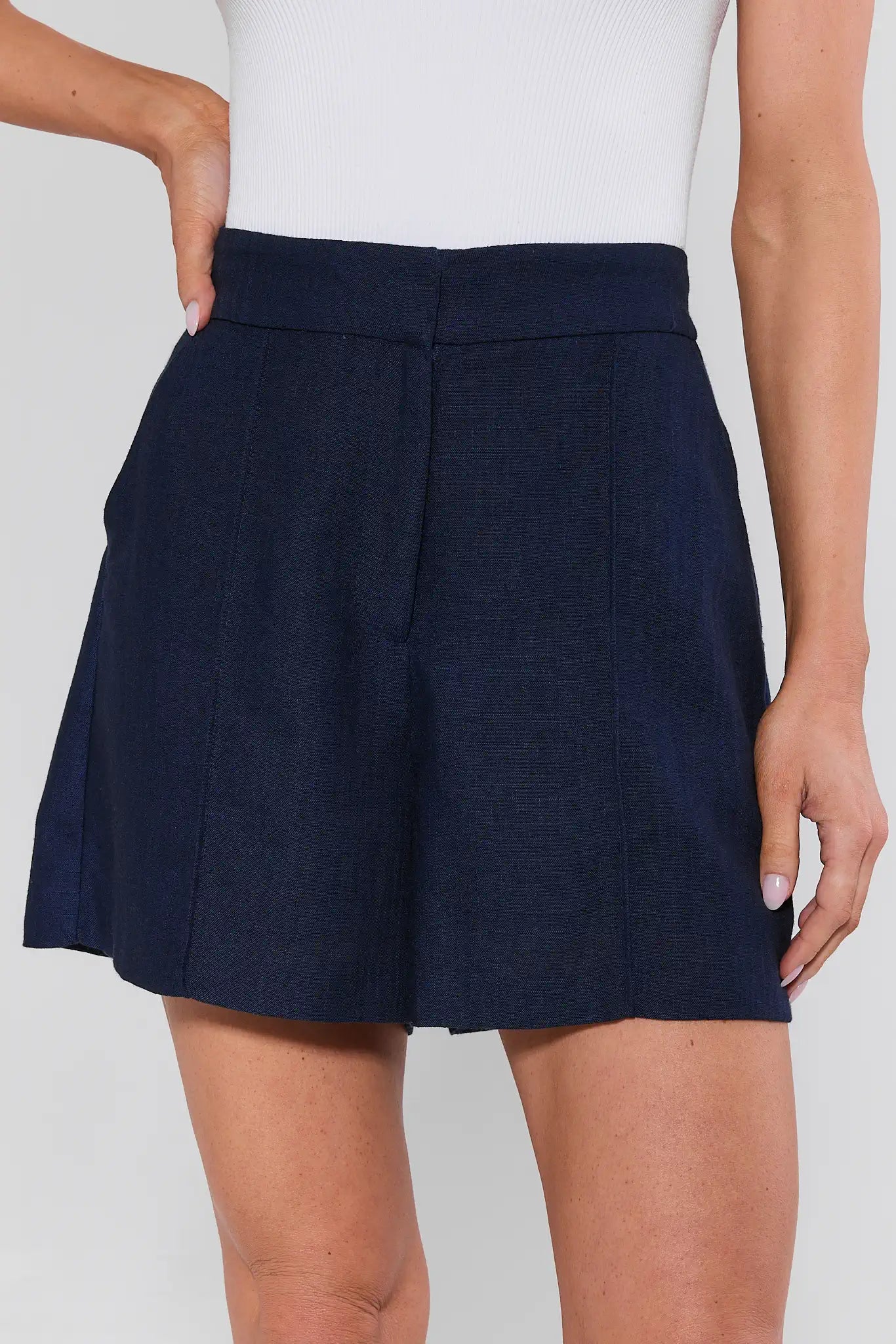 Navy blue skirt worn by a person on a plain background