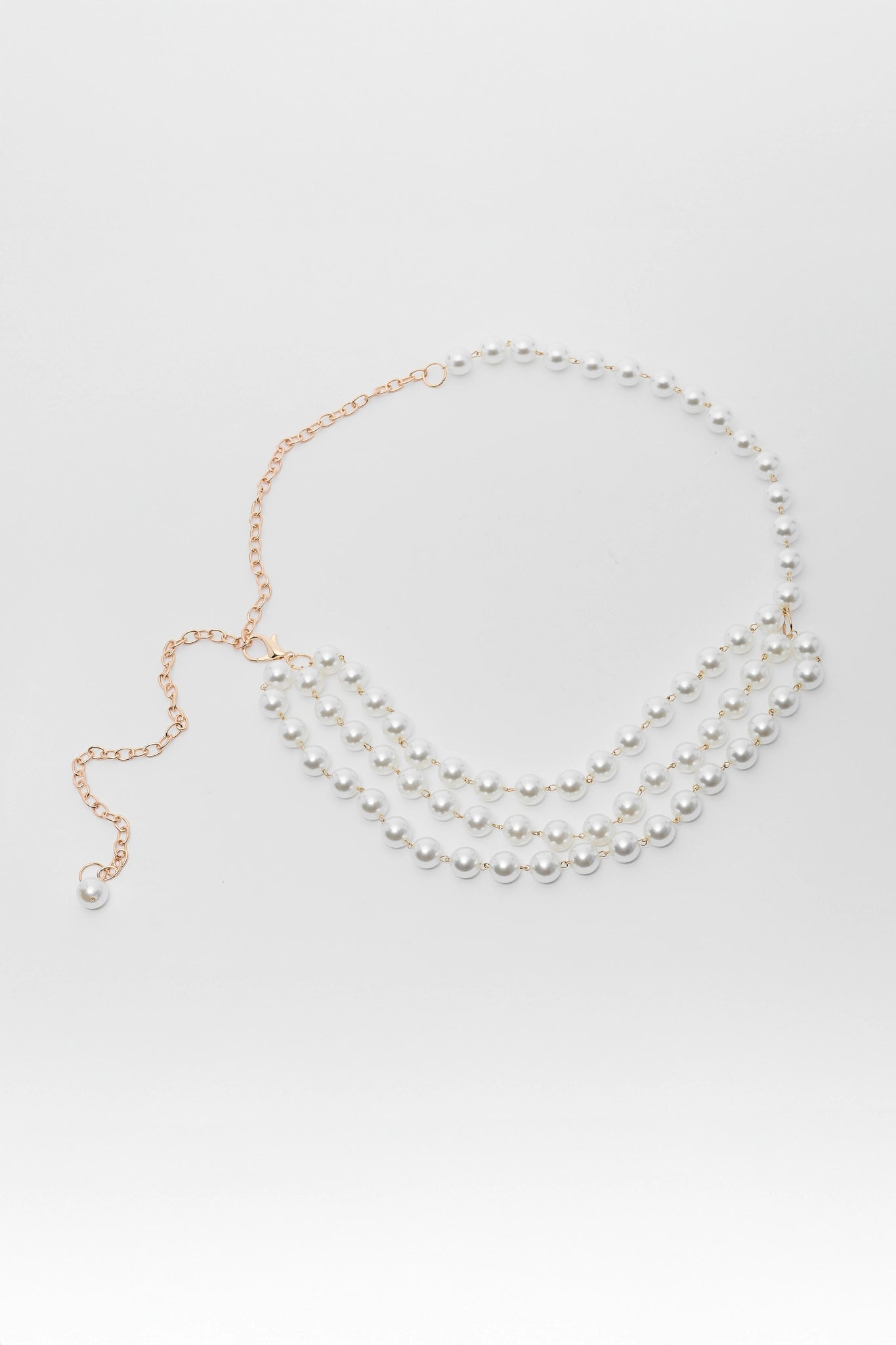 Two pearl necklaces on a light gray background