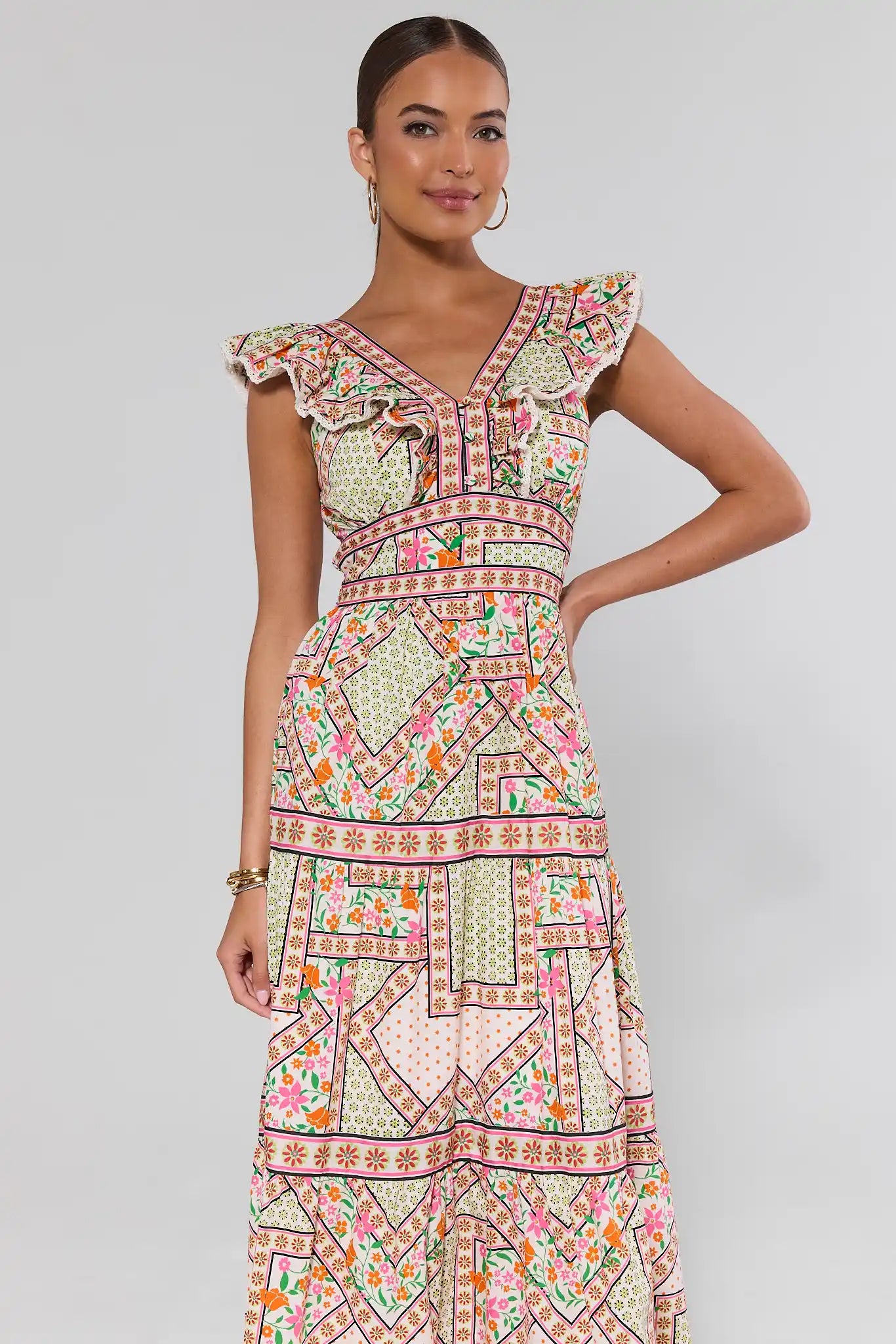 Woman wearing a patterned dress on a gray background