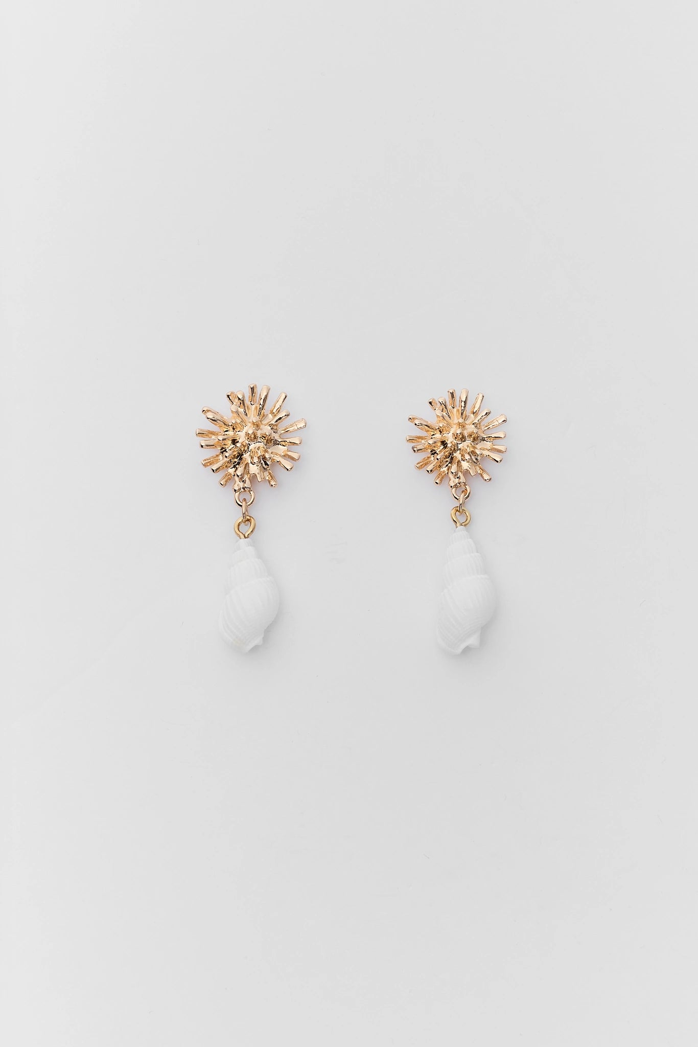 Pair of gold star-shaped earrings on a light gray background