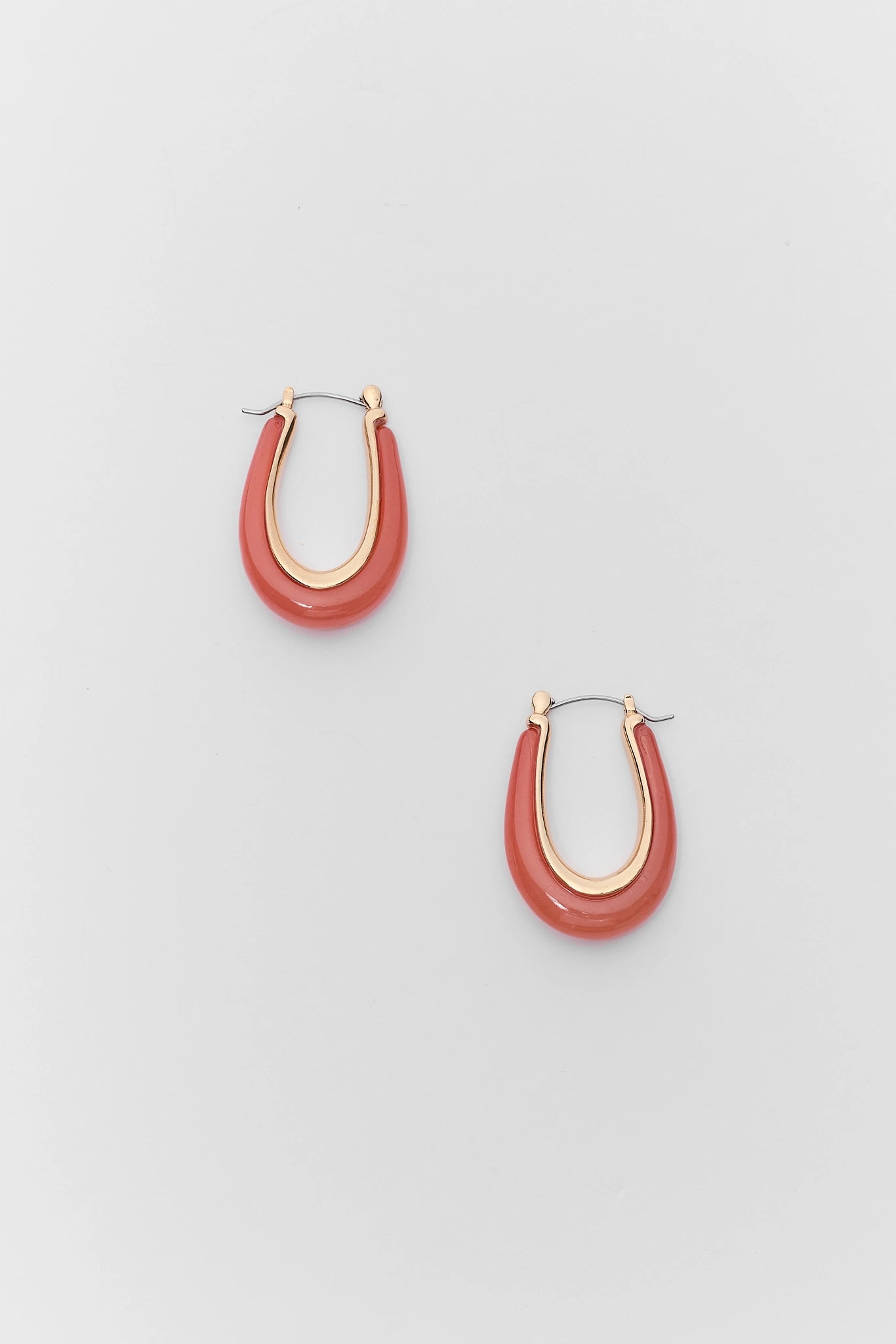 Pair of red hoop earrings on a light gray background