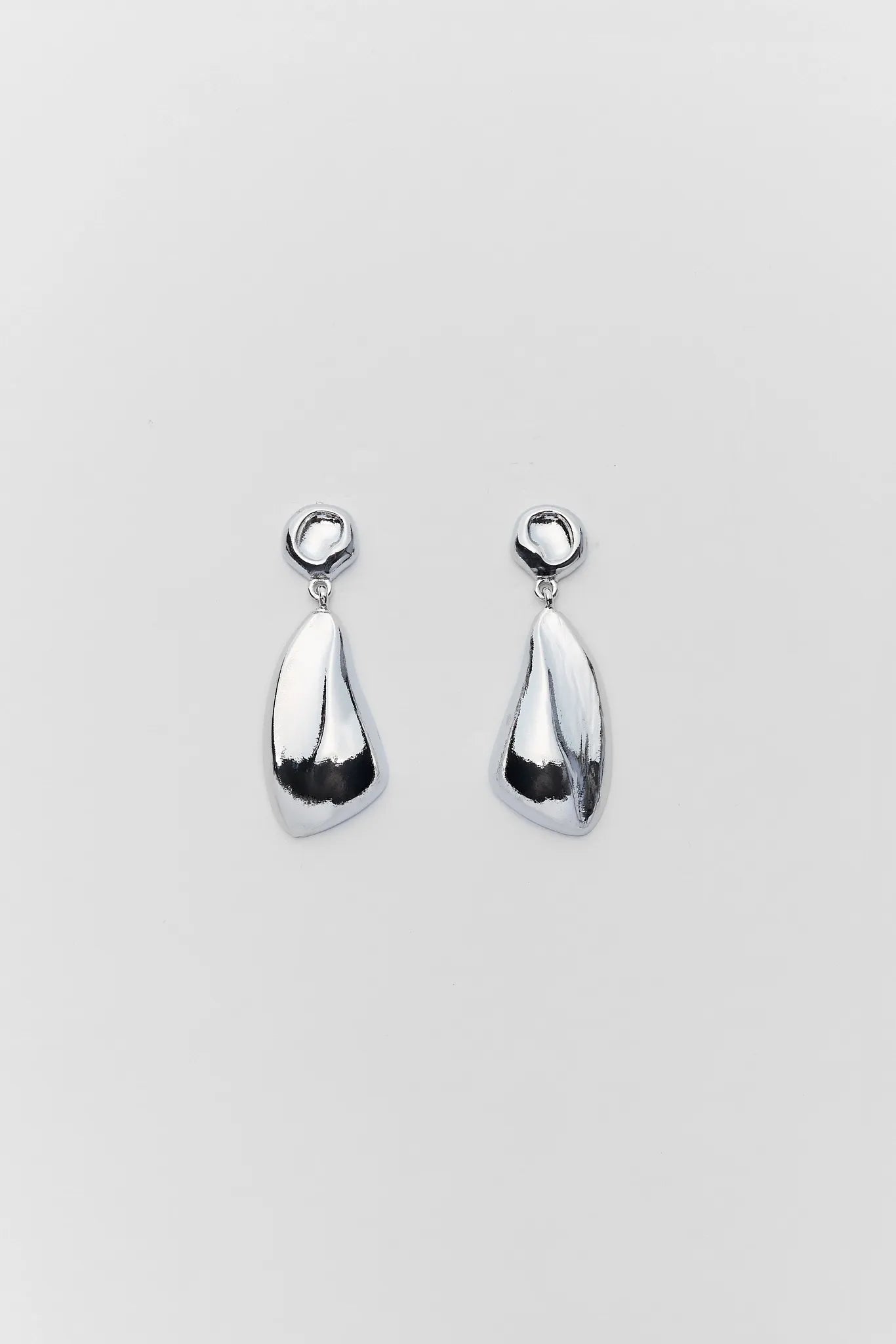 Pair of silver teardrop earrings on a light gray background