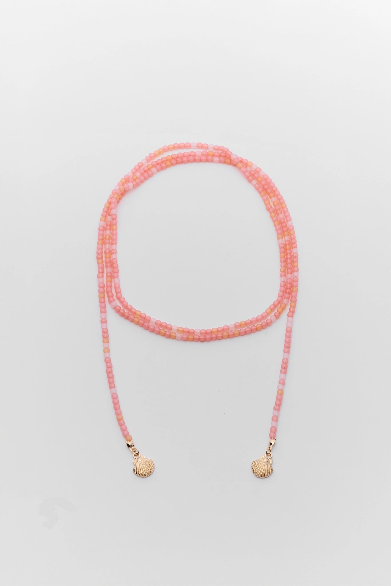 Necklace with pink beads on a light gray background