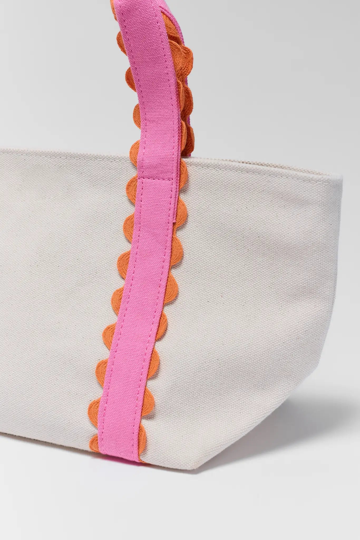 close up Canvas tote bag with pink and orange accents on a white background