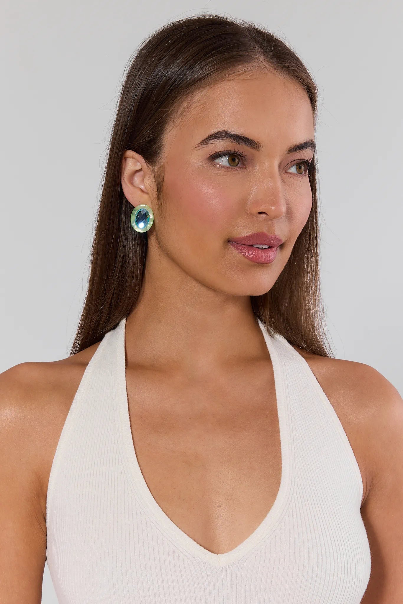 Woman wearing a white halter top against a plain background