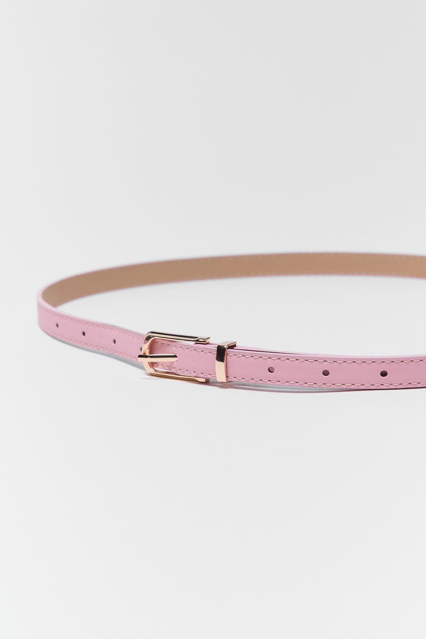 close up of Pink Faux Leather Skinny Belt on white background