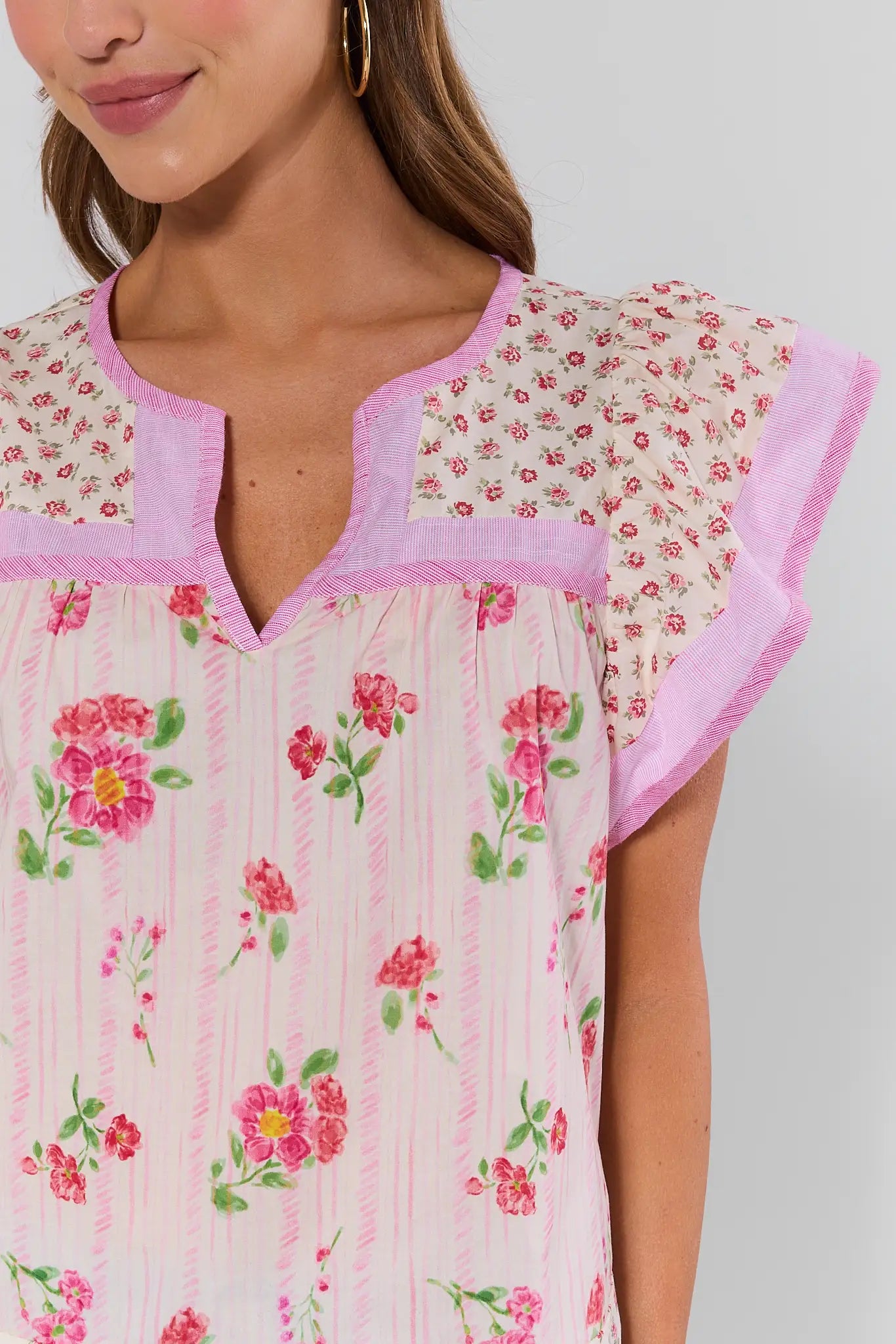 Close-up of a floral dress with pink trim on a plain background