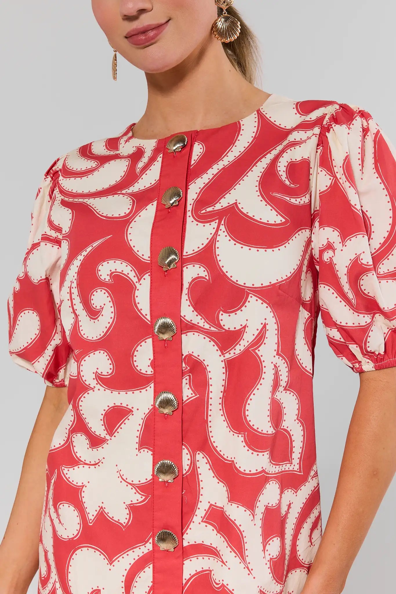 close up Red and white patterned dress with button details on a plain background