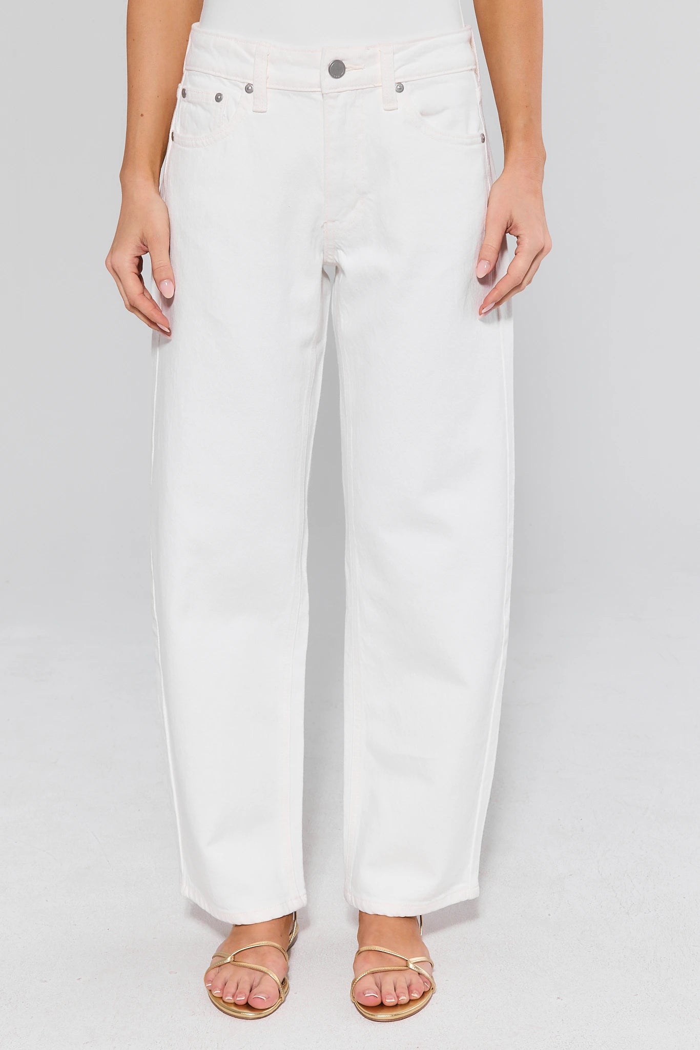 White jeans worn by a person on a white background