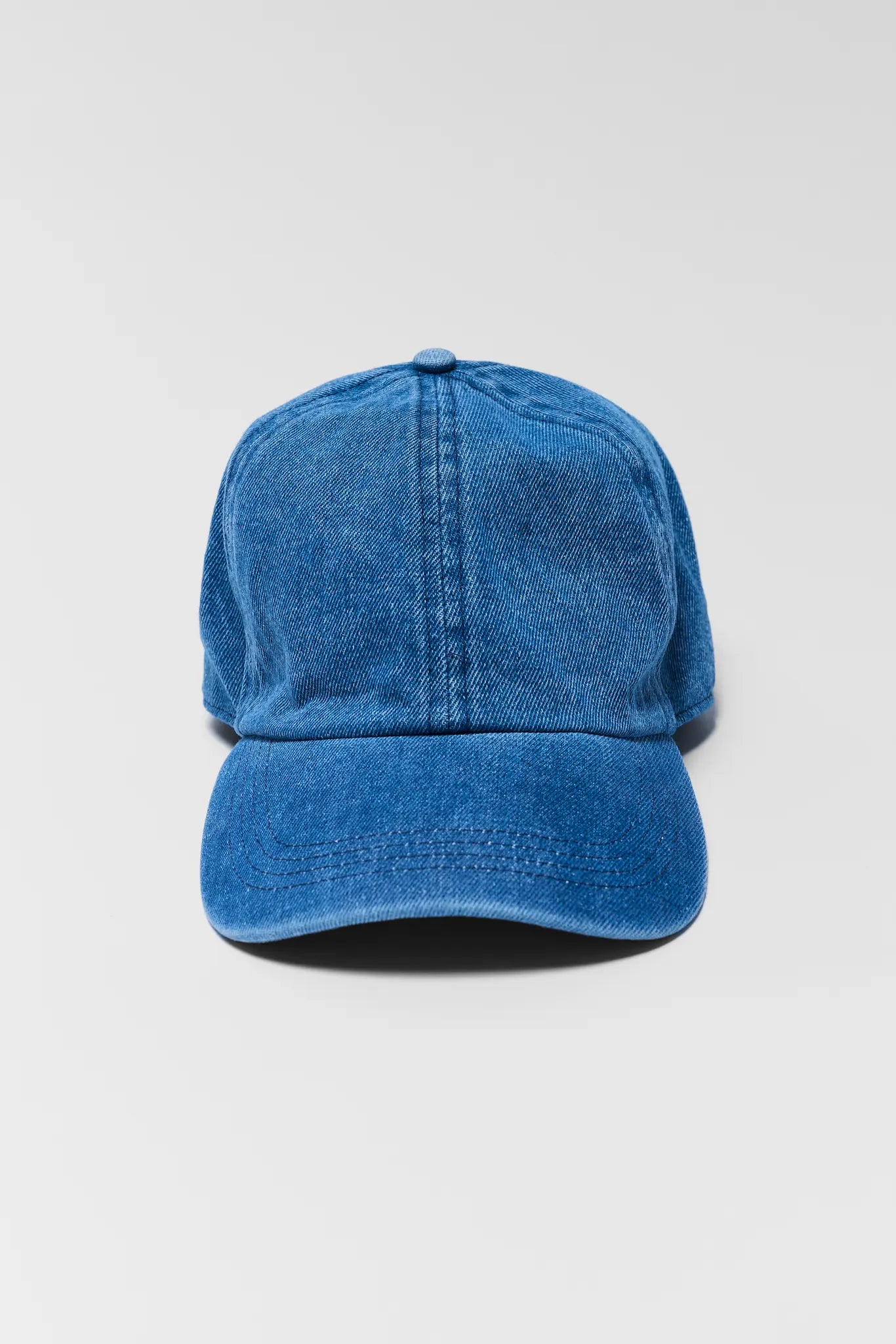 Blue denim cap on a light gray background