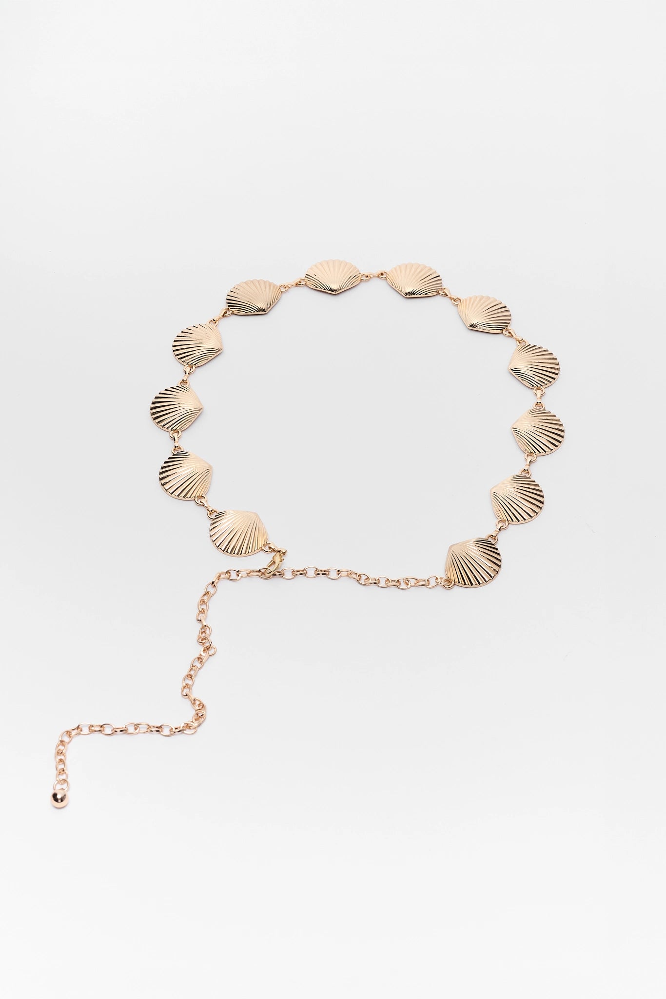 Gold belt with shell-like pendants on a white background