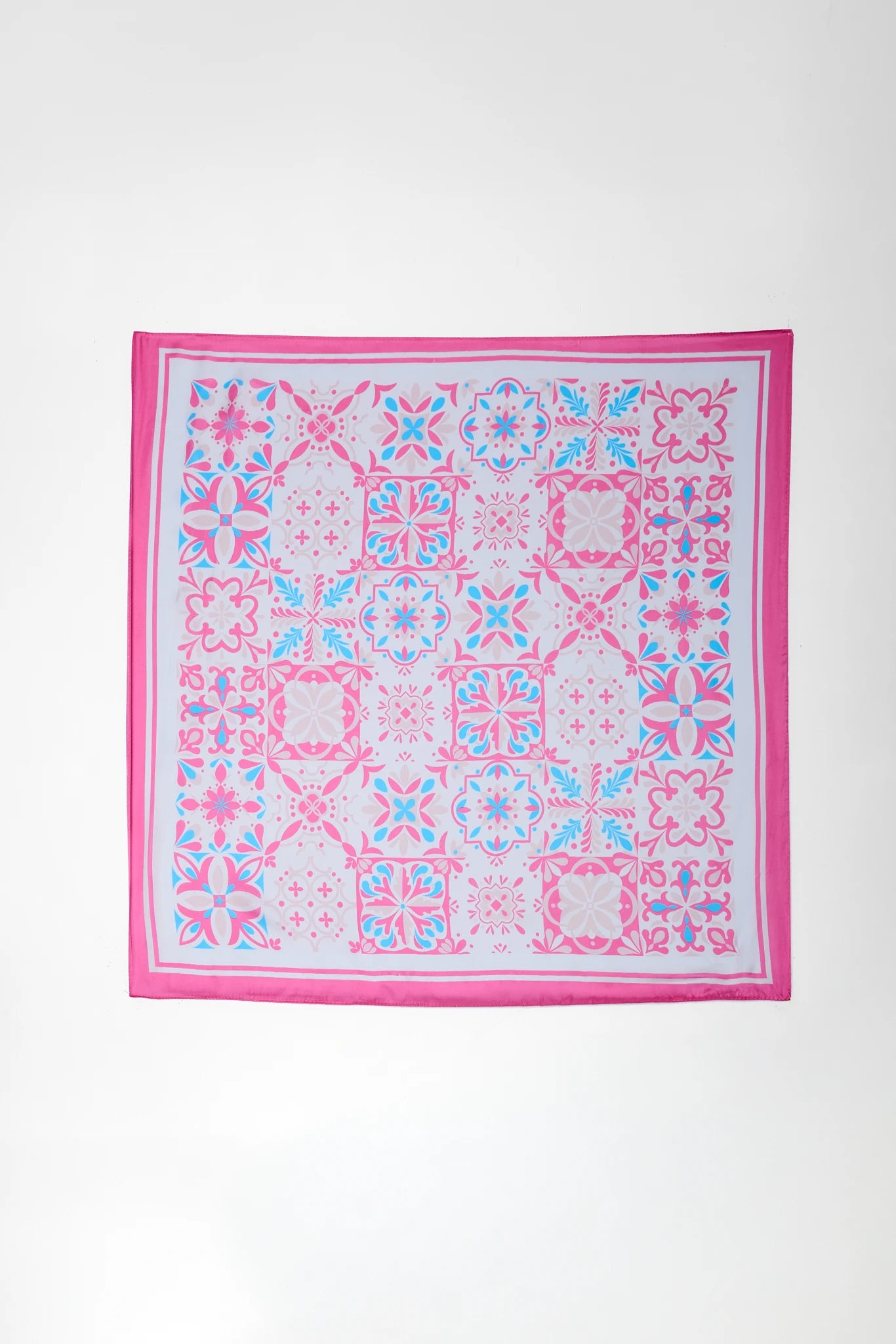 Pink and blue patterned square scarf on a white background