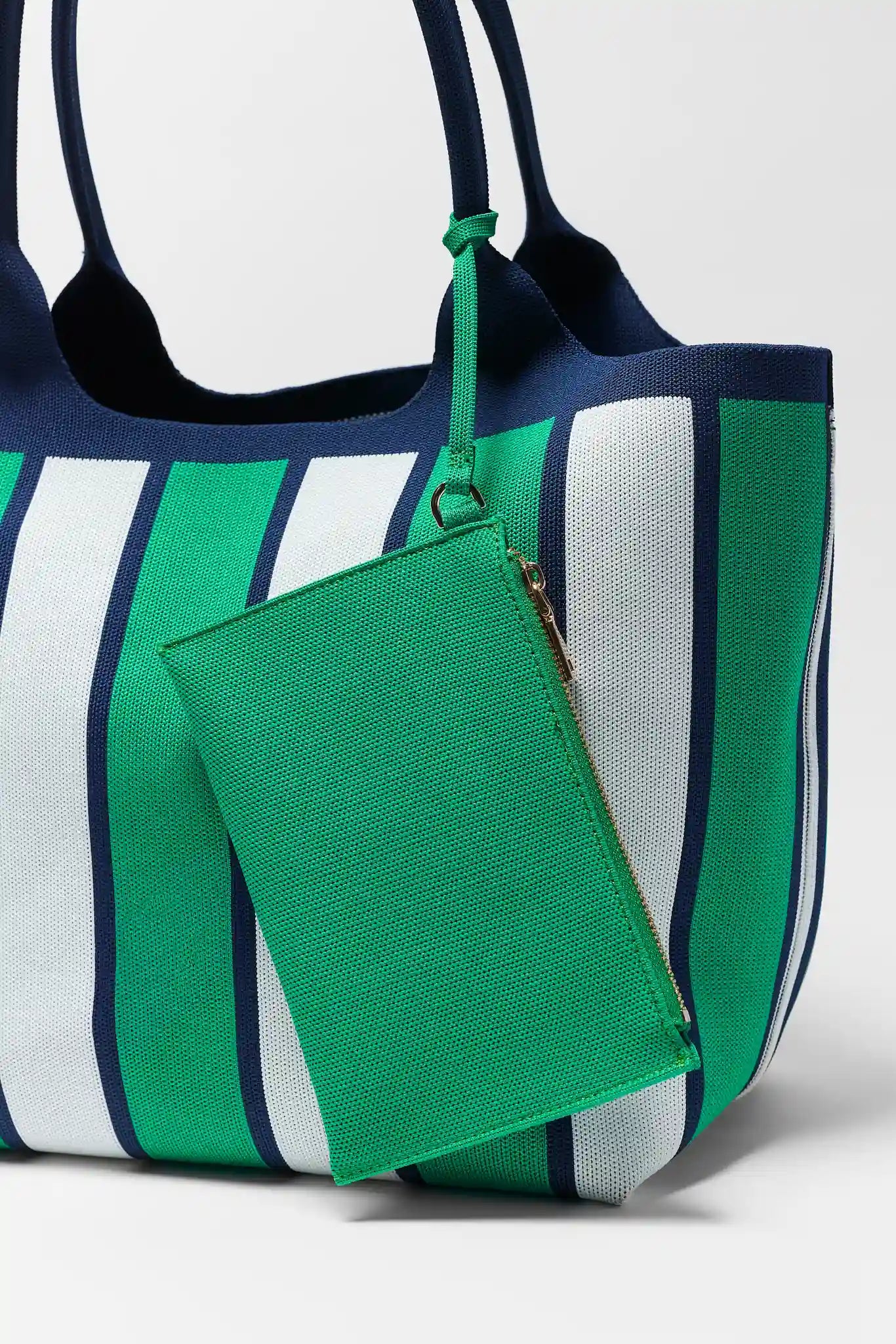 Striped tote bag with a green pouch attached on a white background