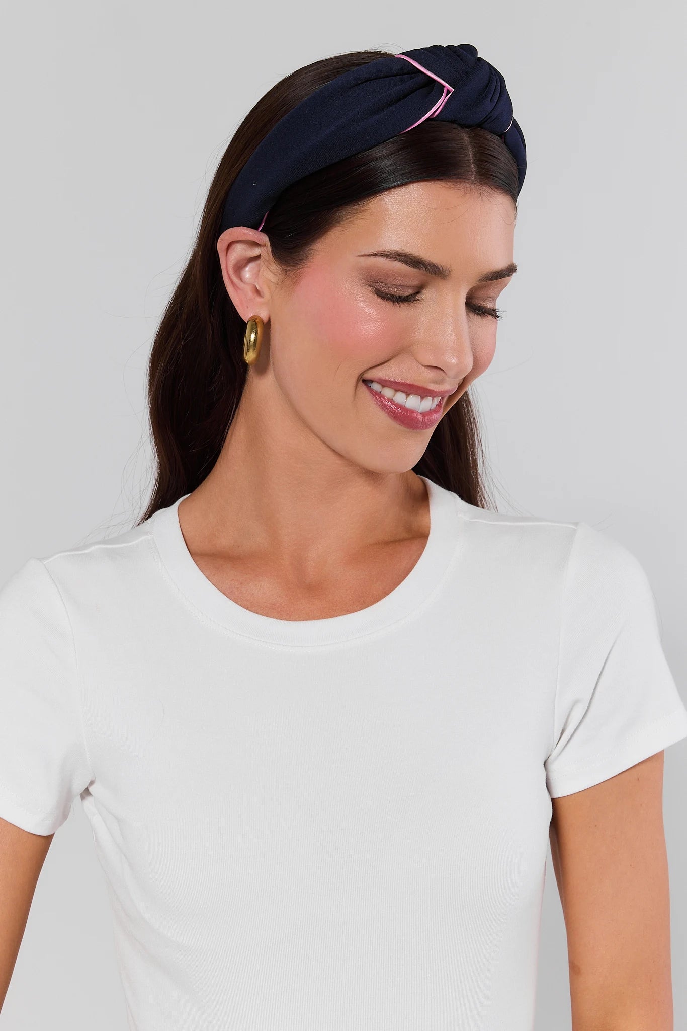 Woman wearing a navy headband with a white background