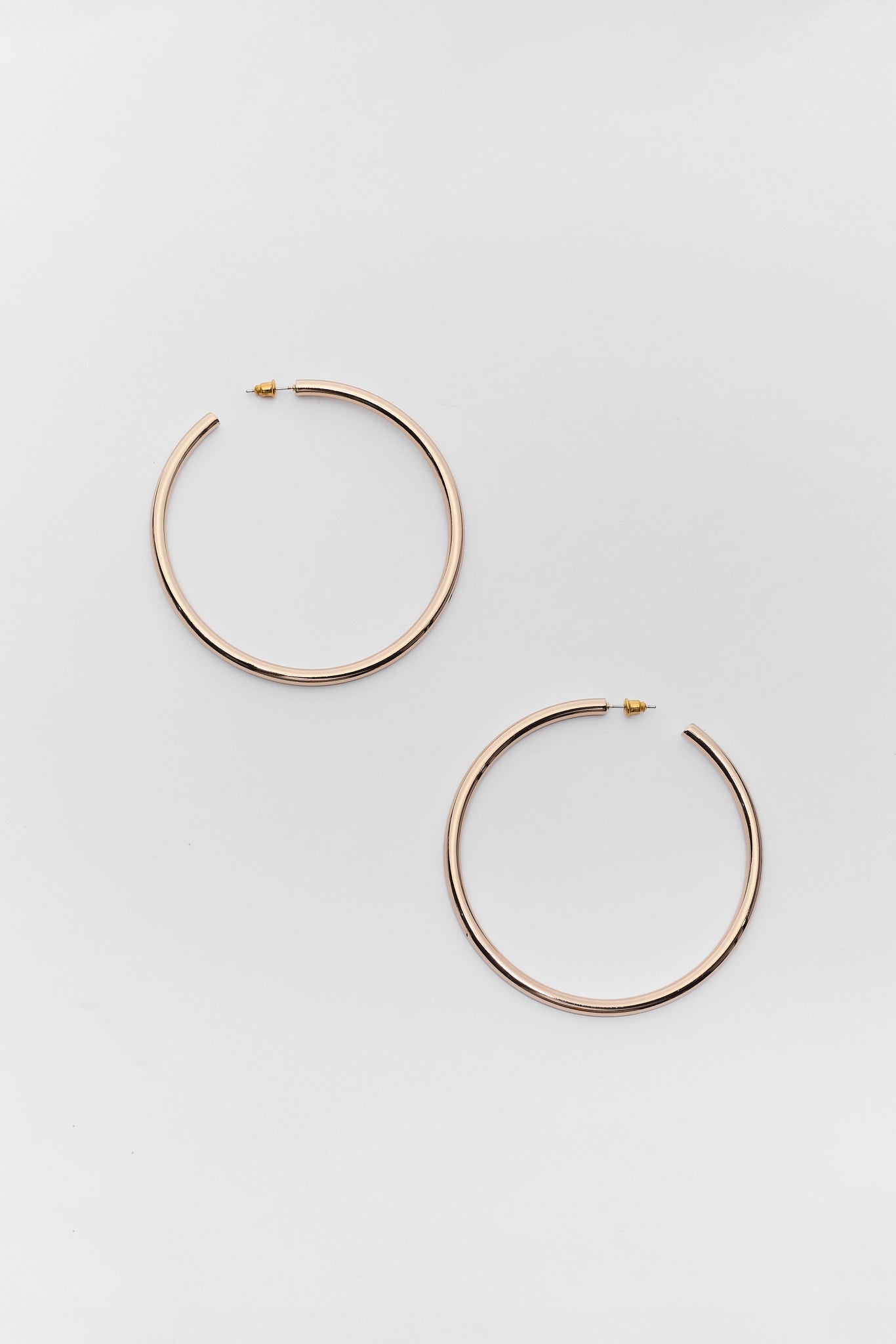 Gold hoop earrings on a light gray background