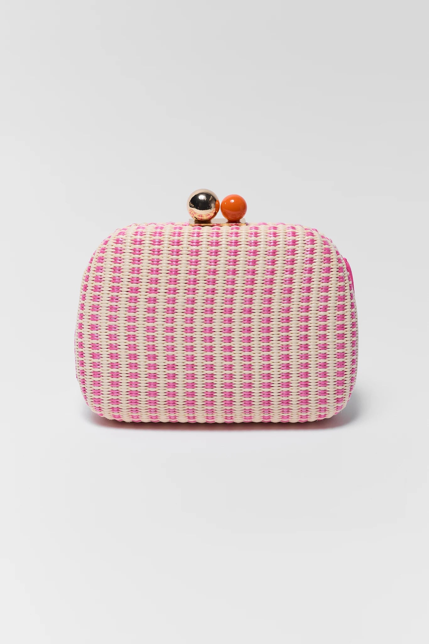 Close up Pink woven clutch bag with decorative elements on a light gray background